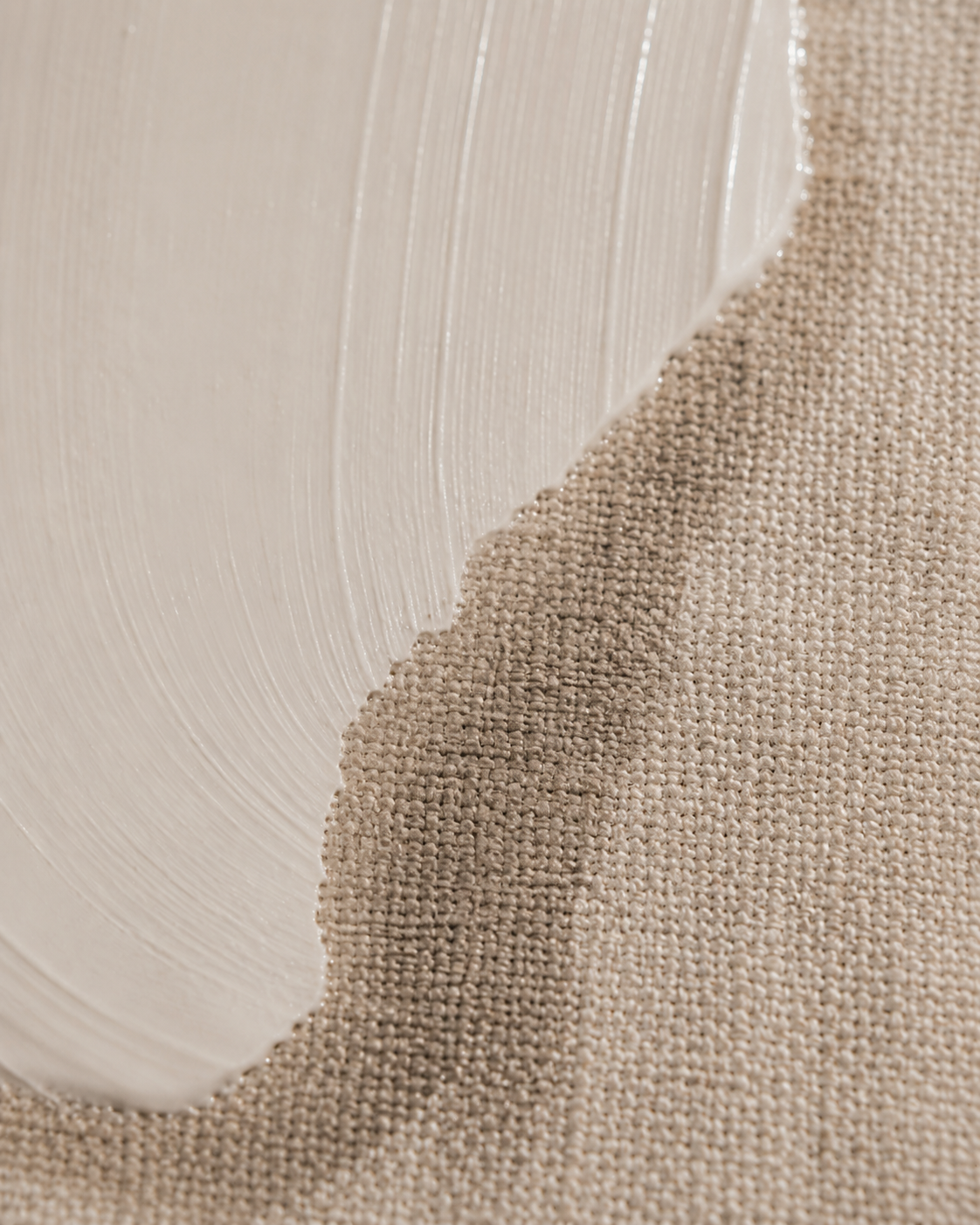 Bord de crème blanche sur tissu lin beige – contraste matières, texture fibre naturelle, fond doux