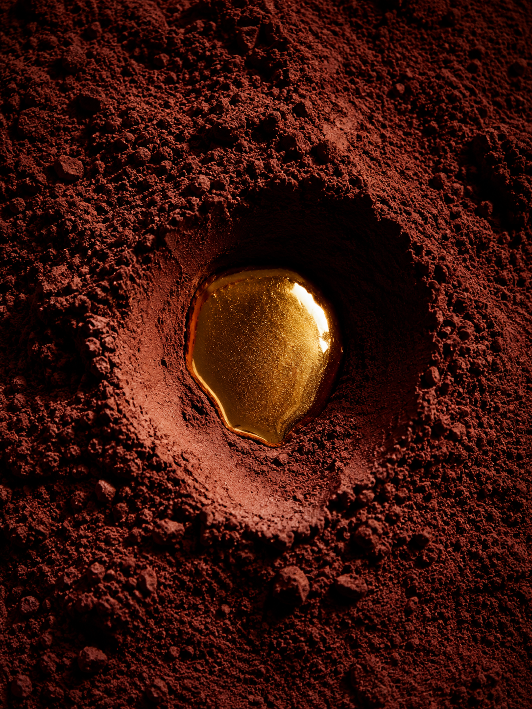 Cavité circulaire dans poudre de cacao avec goutte de caramel – vue de dessus, macro, texture