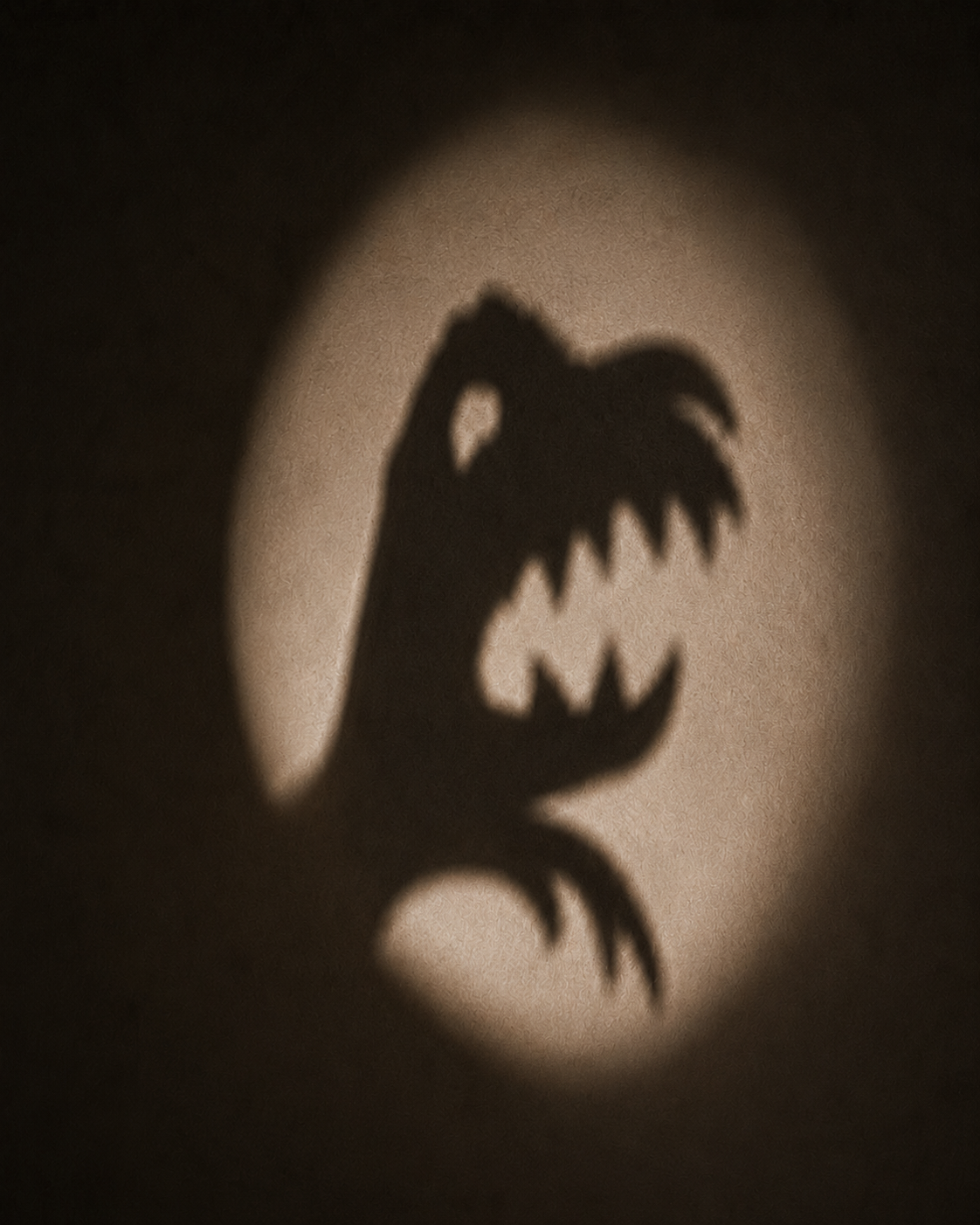 Ombre chinoise d'un monstre sur un mur éclairé par lampe torche – jeu de lumière nocturne