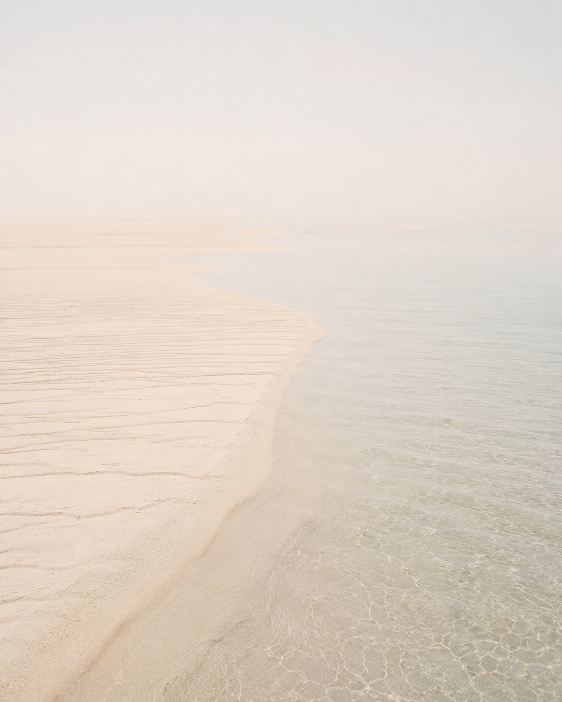 Vue aérienne d'un banc de sable rencontrant l'eau cristalline – composition minimaliste