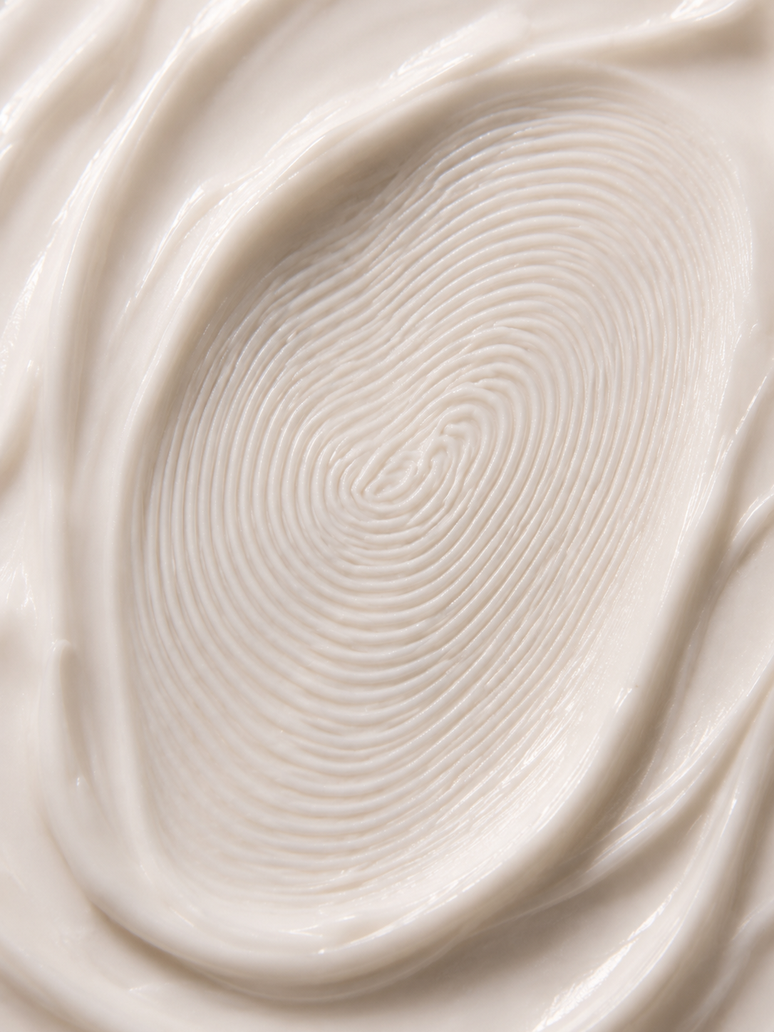 Macro extrême empreinte digitale en spirale dans crème blanche – sillons concentriques, texture soyeuse