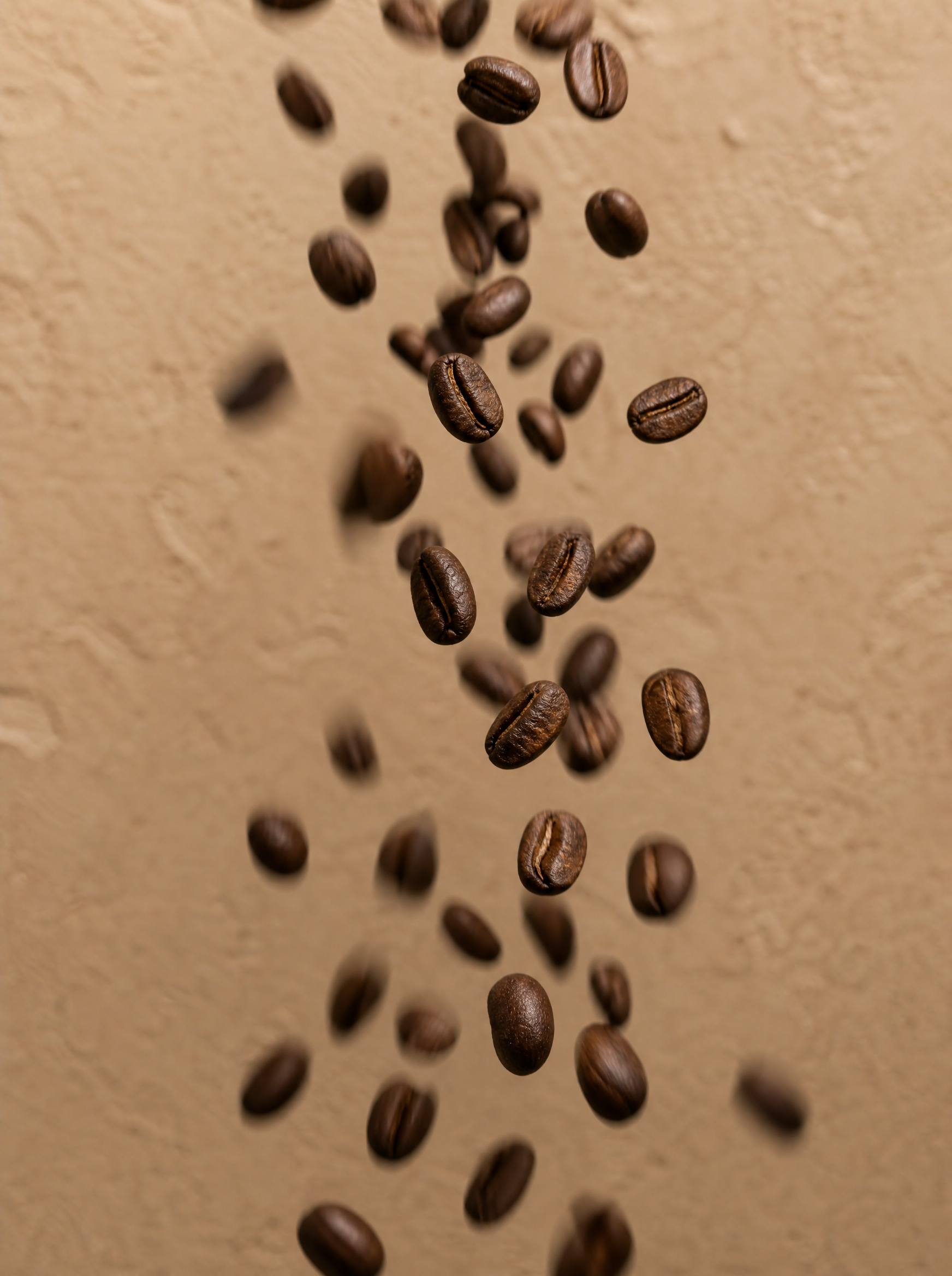 Grains de café torréfiés en chute libre – mouvement, cascade, fond beige texturé
