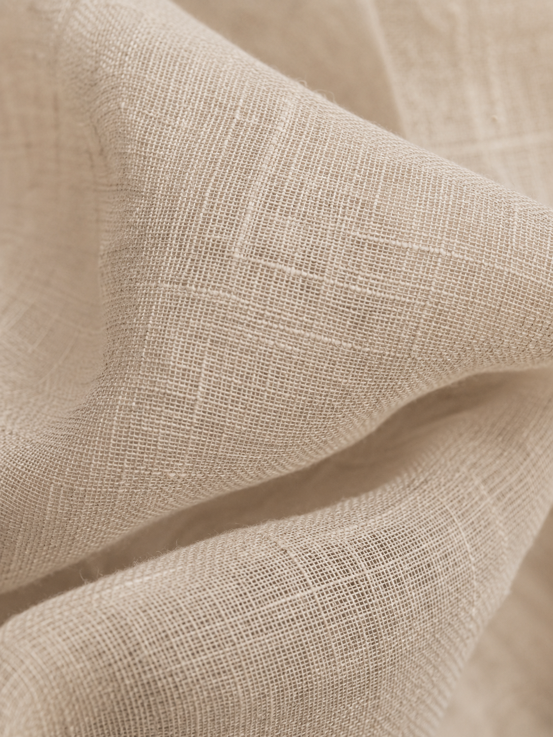 Macro tissu lin beige naturel froissé – texture fibre végétale, plis doux, fond neutre