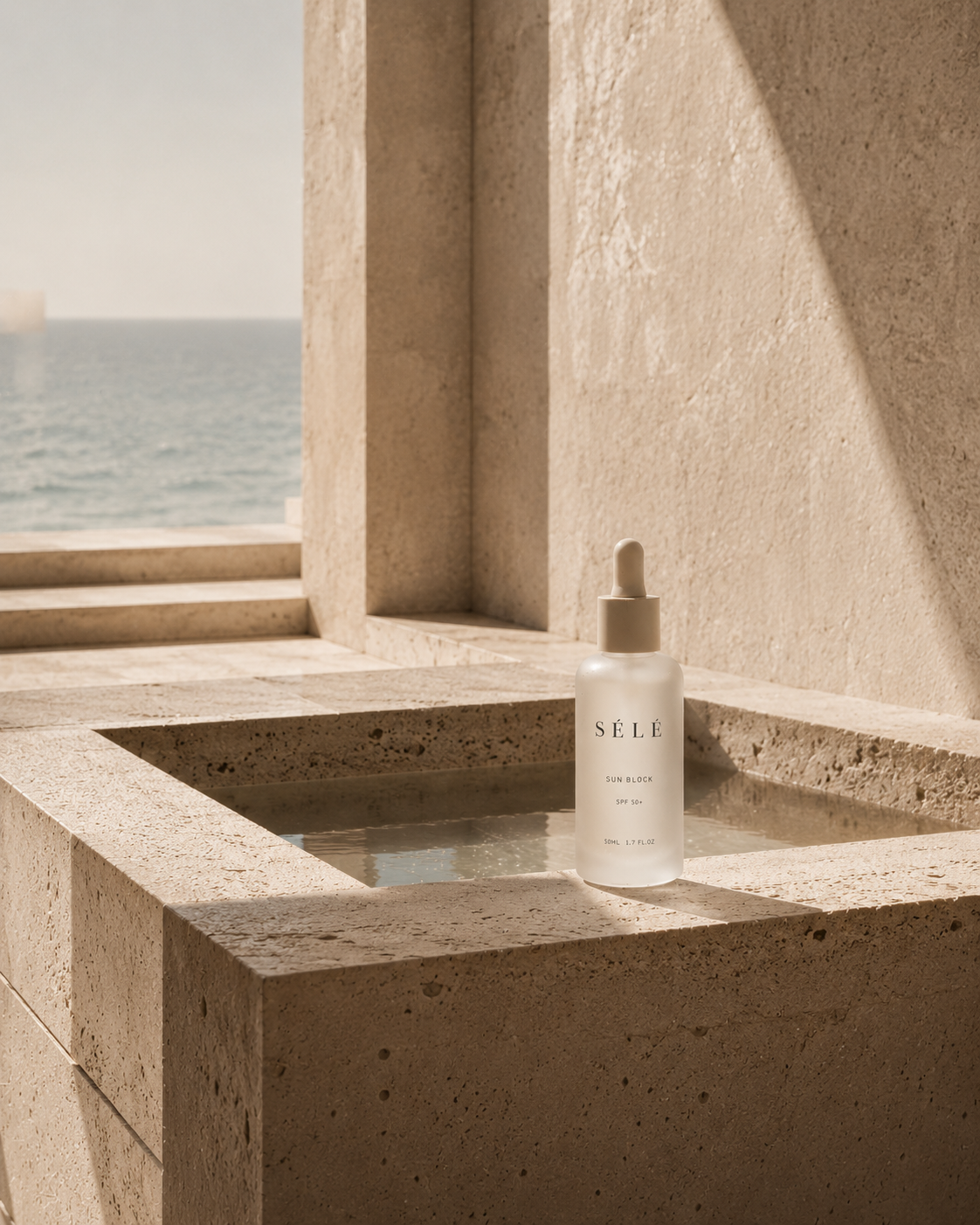 Flacon sérum pipette dans bassin de travertin – architecture côtière luxueuse, mer bleue en fond