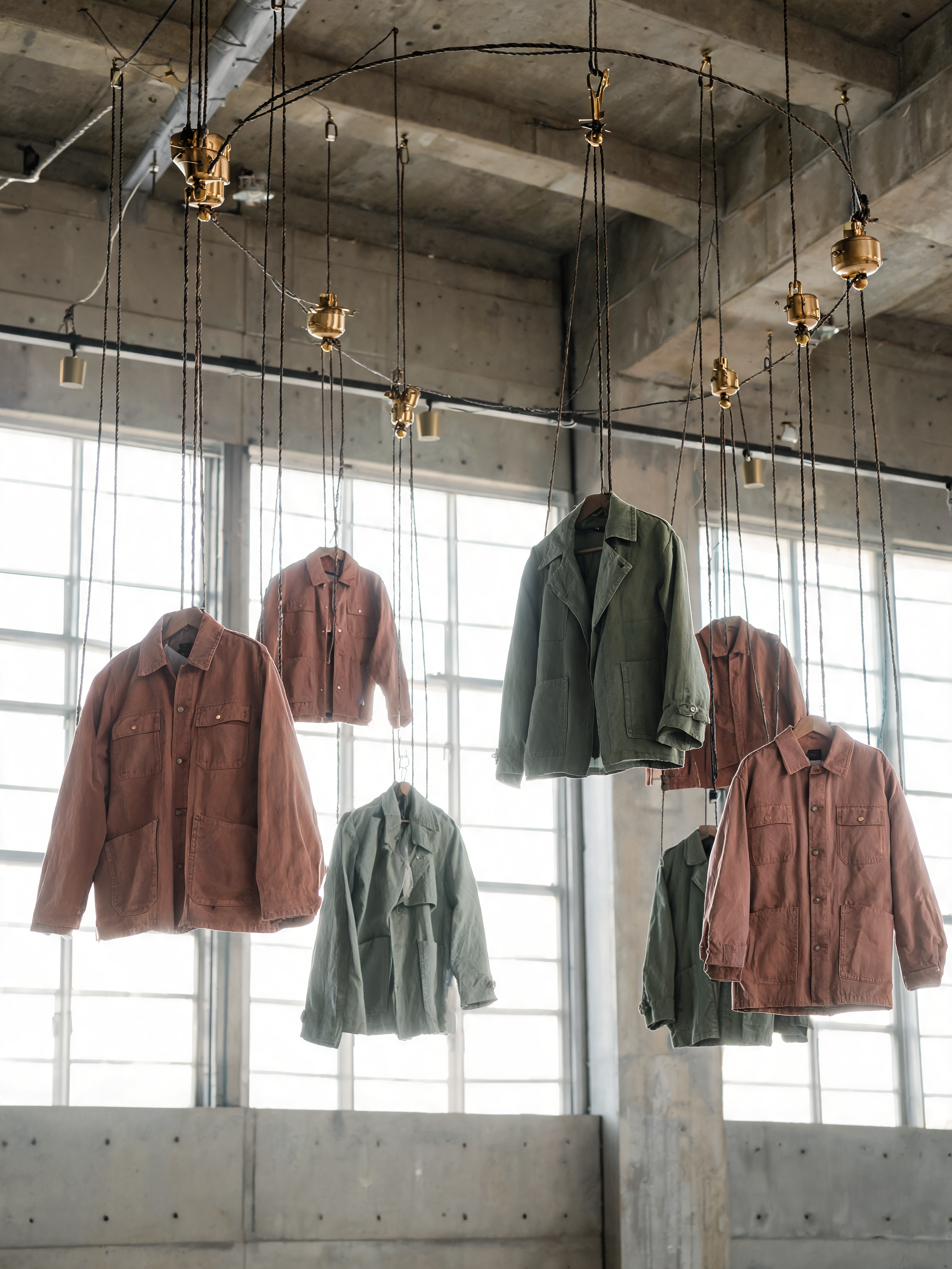 Six vestes suspendues câbles laiton rail plafond – terracotta et kaki, installation, atelier
