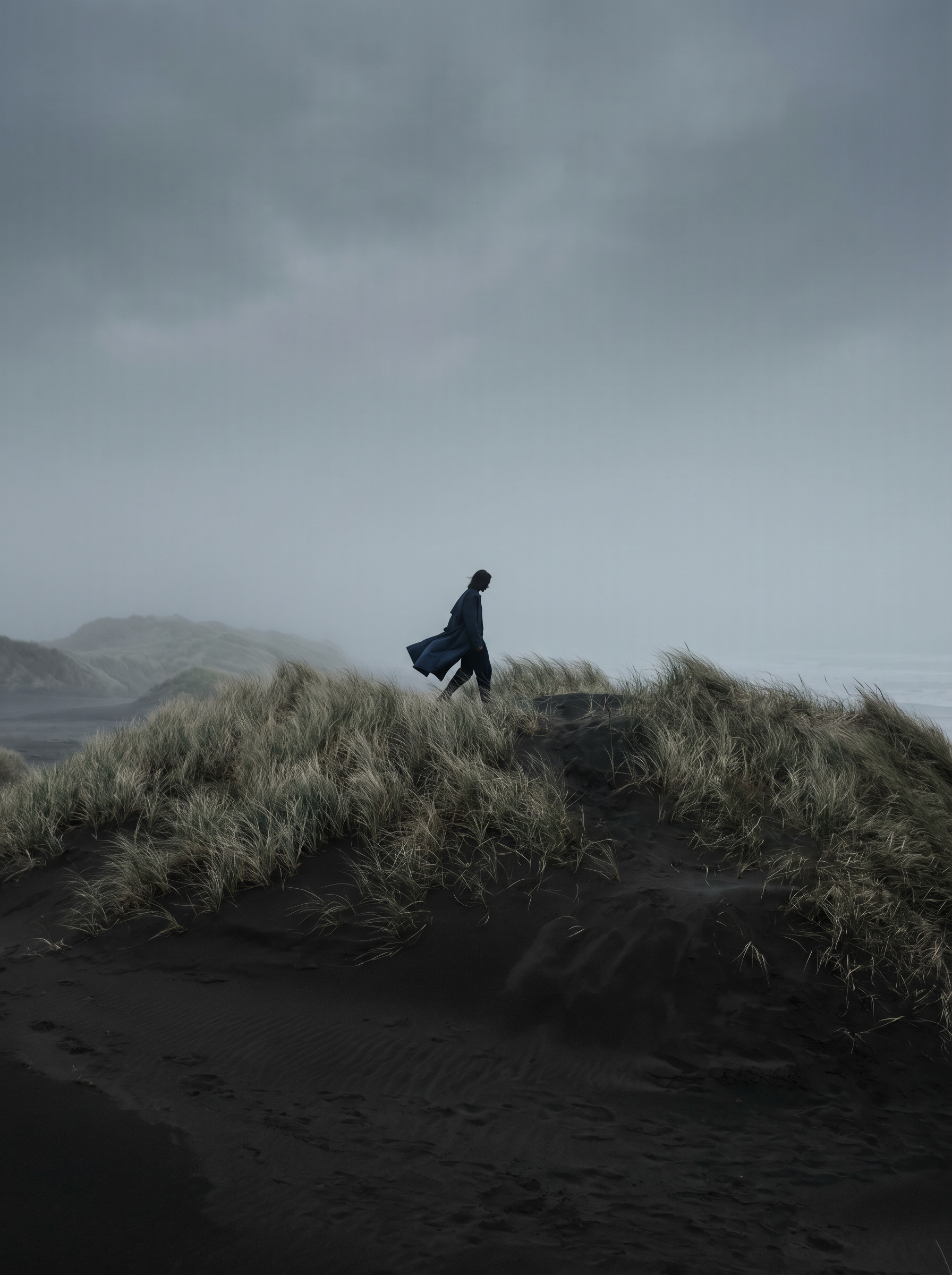 Silhouette marchant sur les dunes par temps nuageux