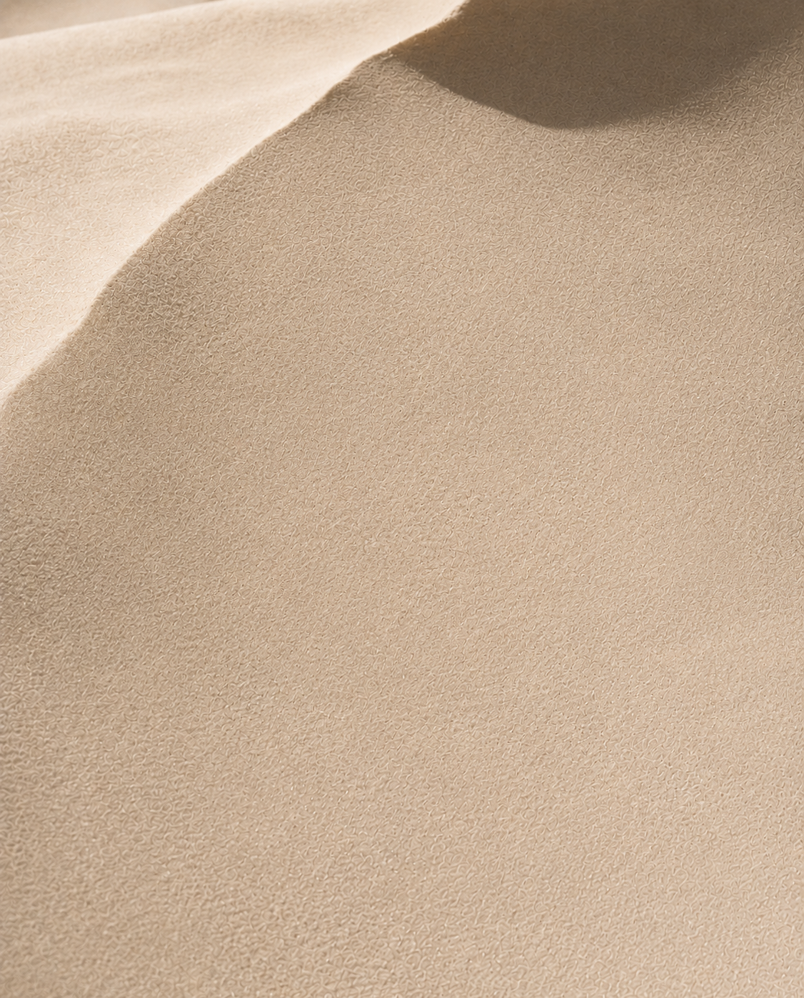 Macro texture de dune de sable fin – ondulations, courbes douces, lumière rasante, ombre