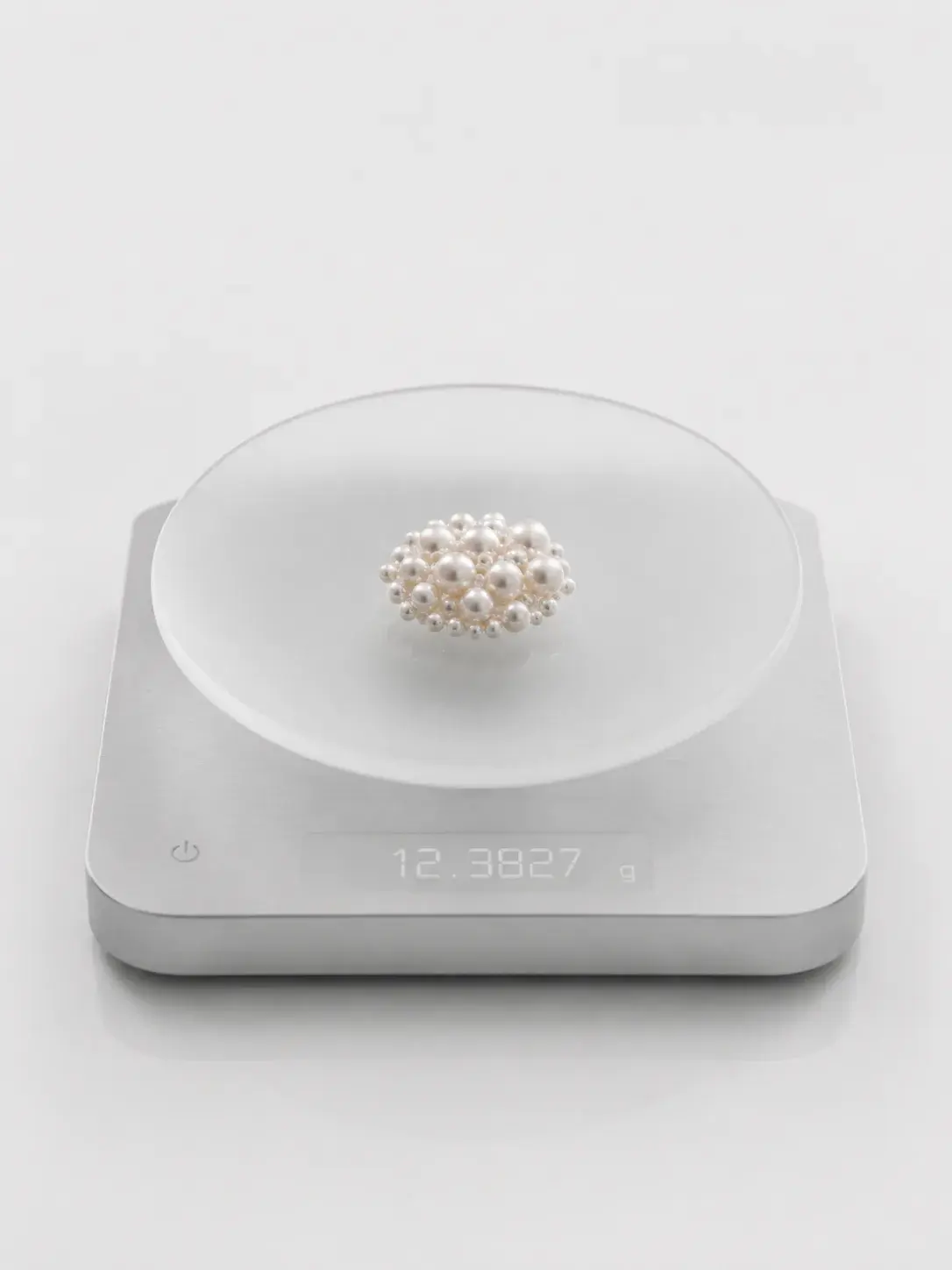 Amas de perles de culture sur balance de précision digitale, pesée nacrée entre science et luxe