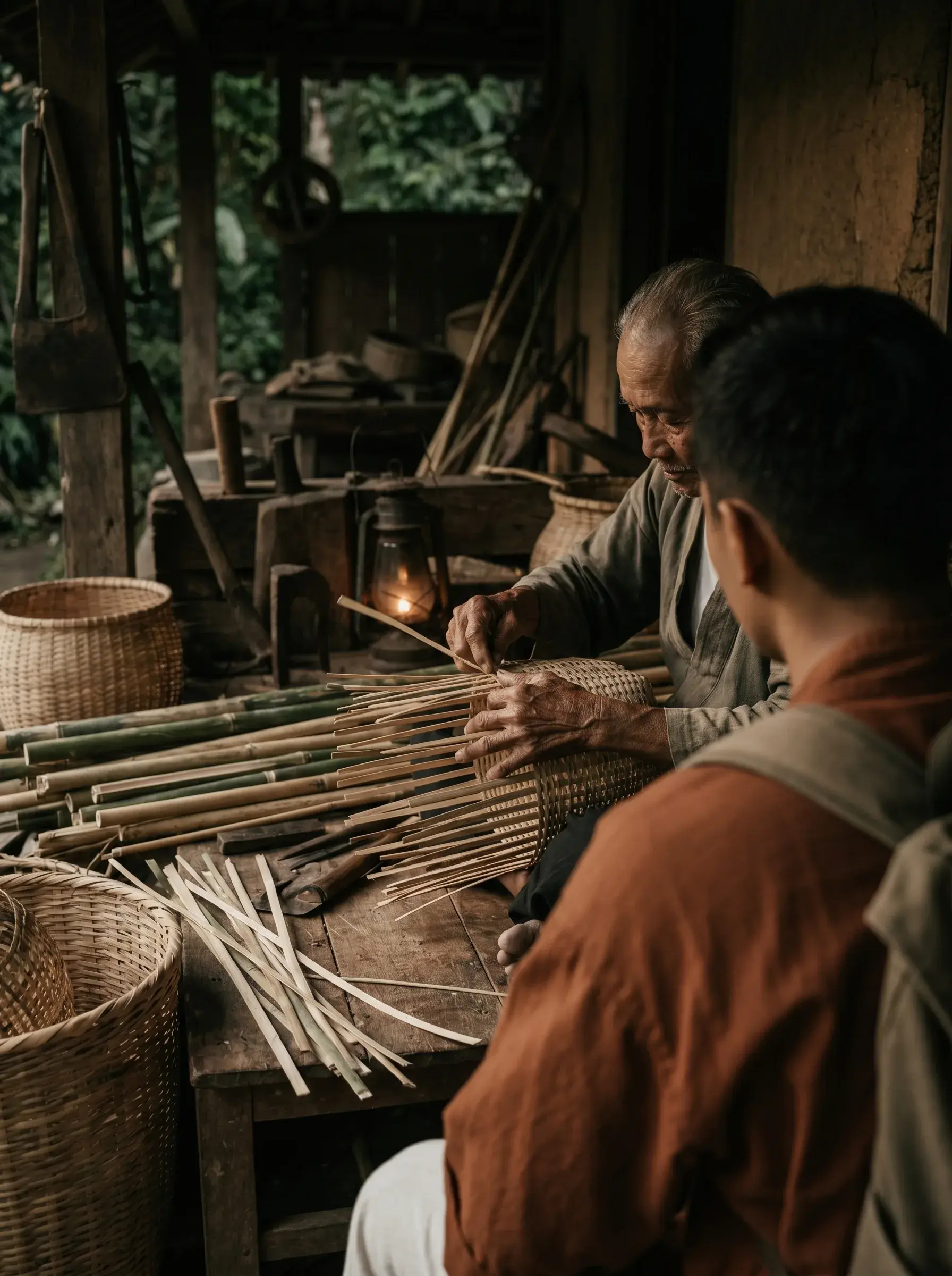 Artisan âgé et apprenti tressant le bambou en atelier rustique – Asie, lumière tamisée