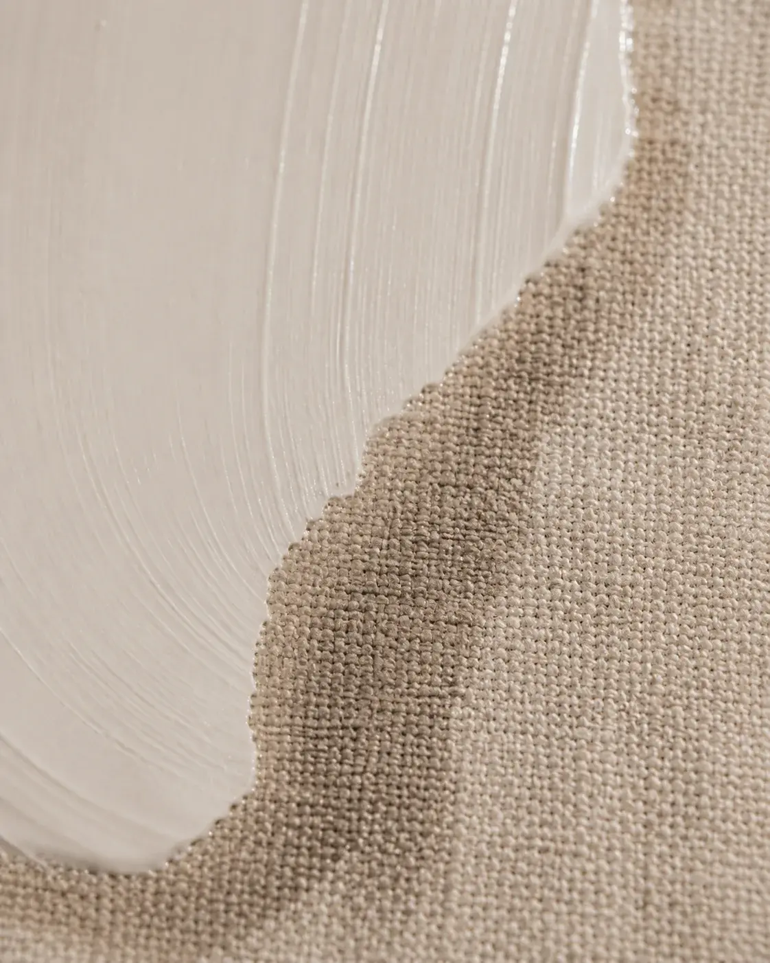 Bord de crème blanche sur tissu lin beige – contraste matières, texture fibre naturelle, fond doux