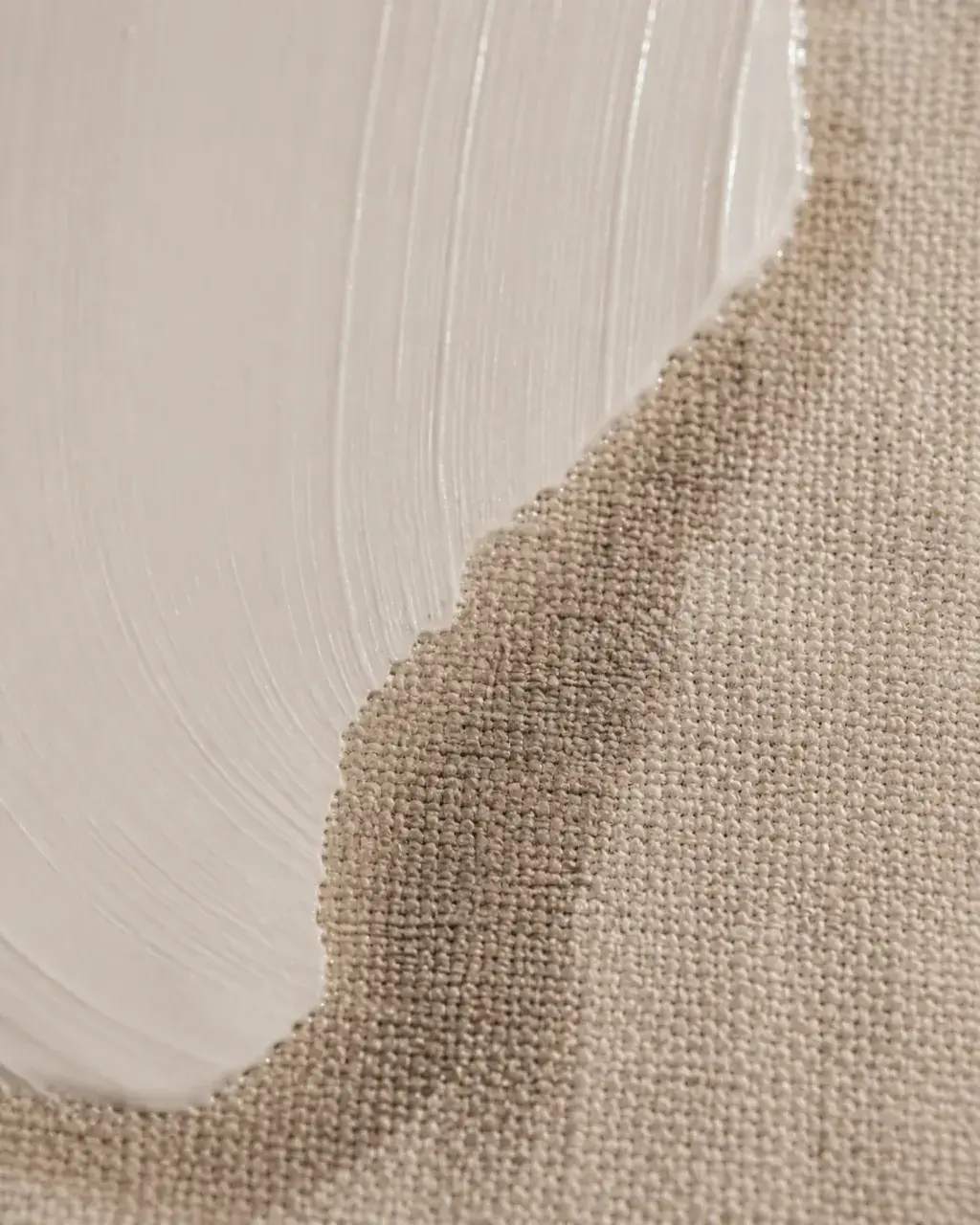 Bord de crème blanche sur tissu lin beige – contraste matières, texture fibre naturelle, fond doux