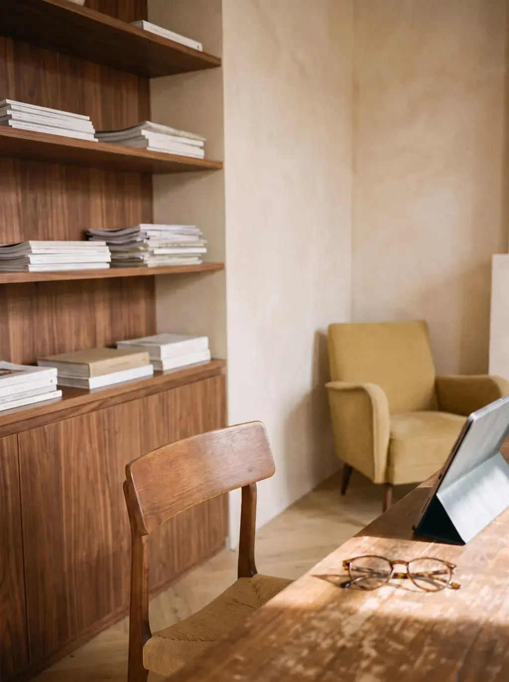 Bureau vide chaleureux avec tablette, lunettes et étagère en bois