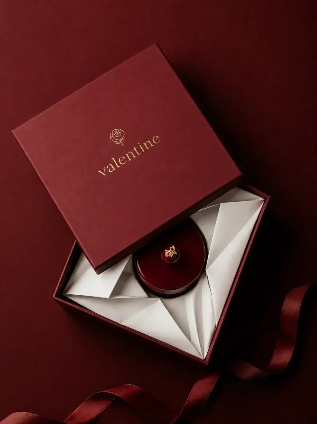 Coffret cadeau pâtisserie bordeaux ouvert – entremets glaçage rouge, papier plissé, ruban satin