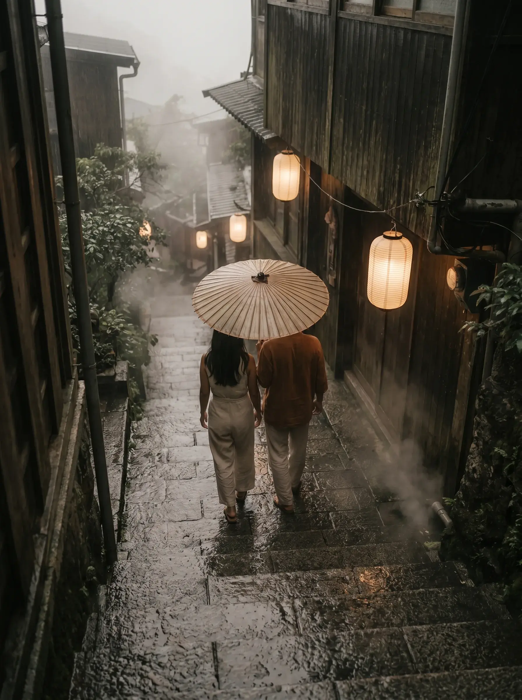 Couple de dos sous parapluie de papier huilé dans ruelle japonaise sombre et pluvieuse, lanternes rondes allumées et vapeur