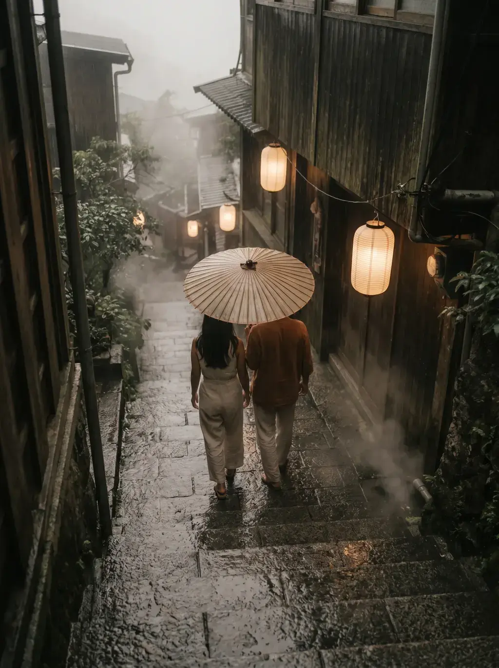 Couple de dos sous parapluie de papier huilé dans ruelle japonaise sombre et pluvieuse, lanternes rondes allumées et vapeur