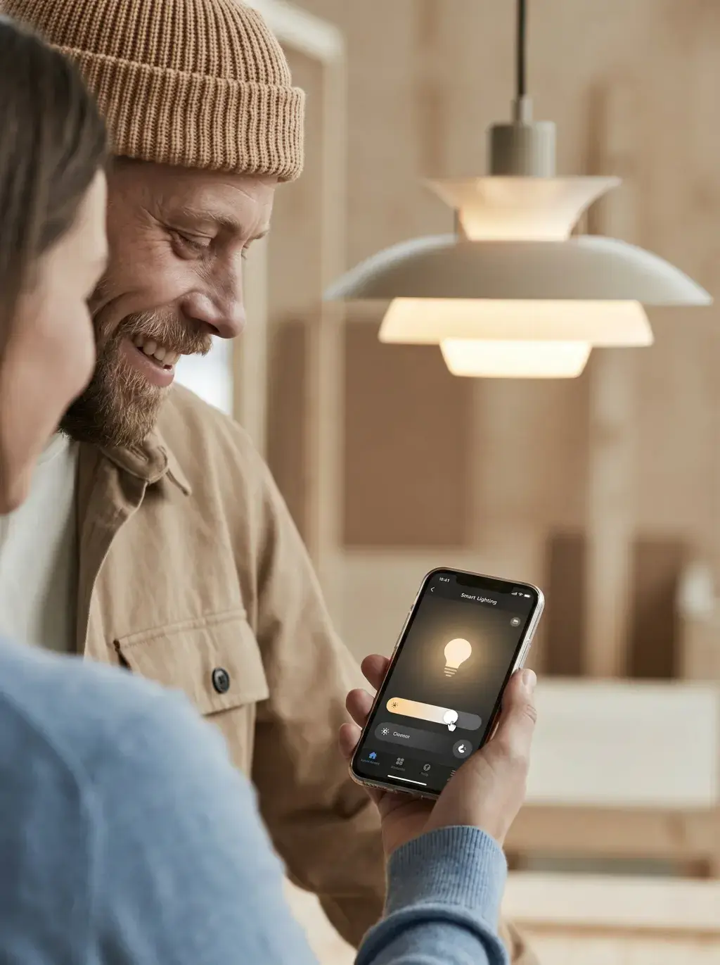Couple souriant pilotant une suspension PH connectée depuis une application smartphone
