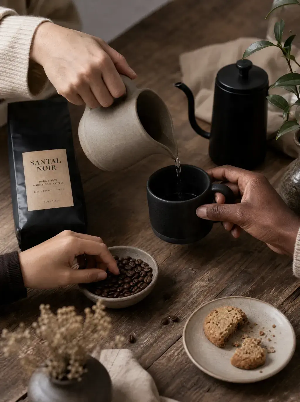 Deux mains versant café – cafetière céramique, sachet artisanal, grains, biscuit, table bois