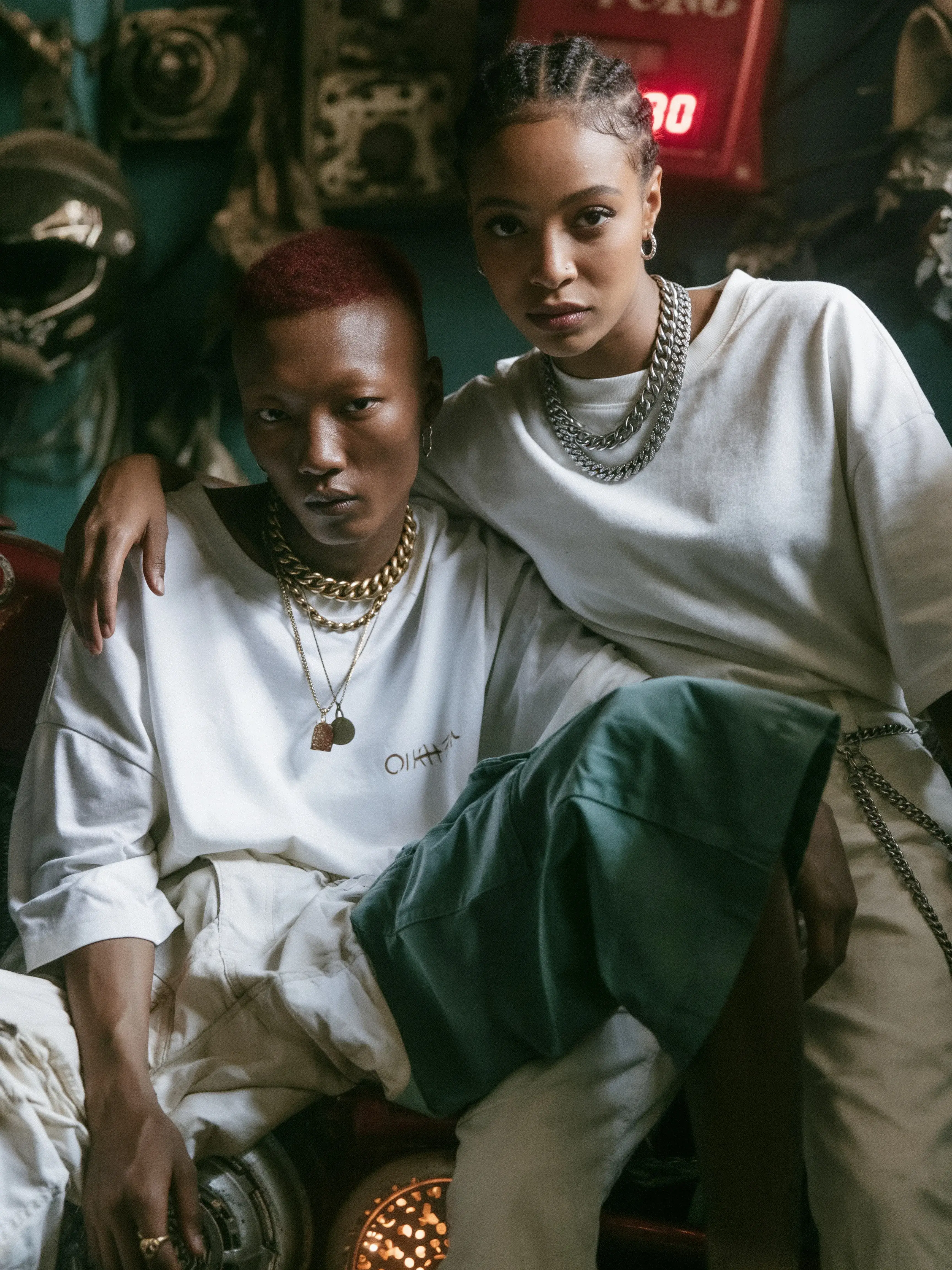 Duo mode homme aux cheveux rouges et femme aux tresses dans un atelier moto vintage