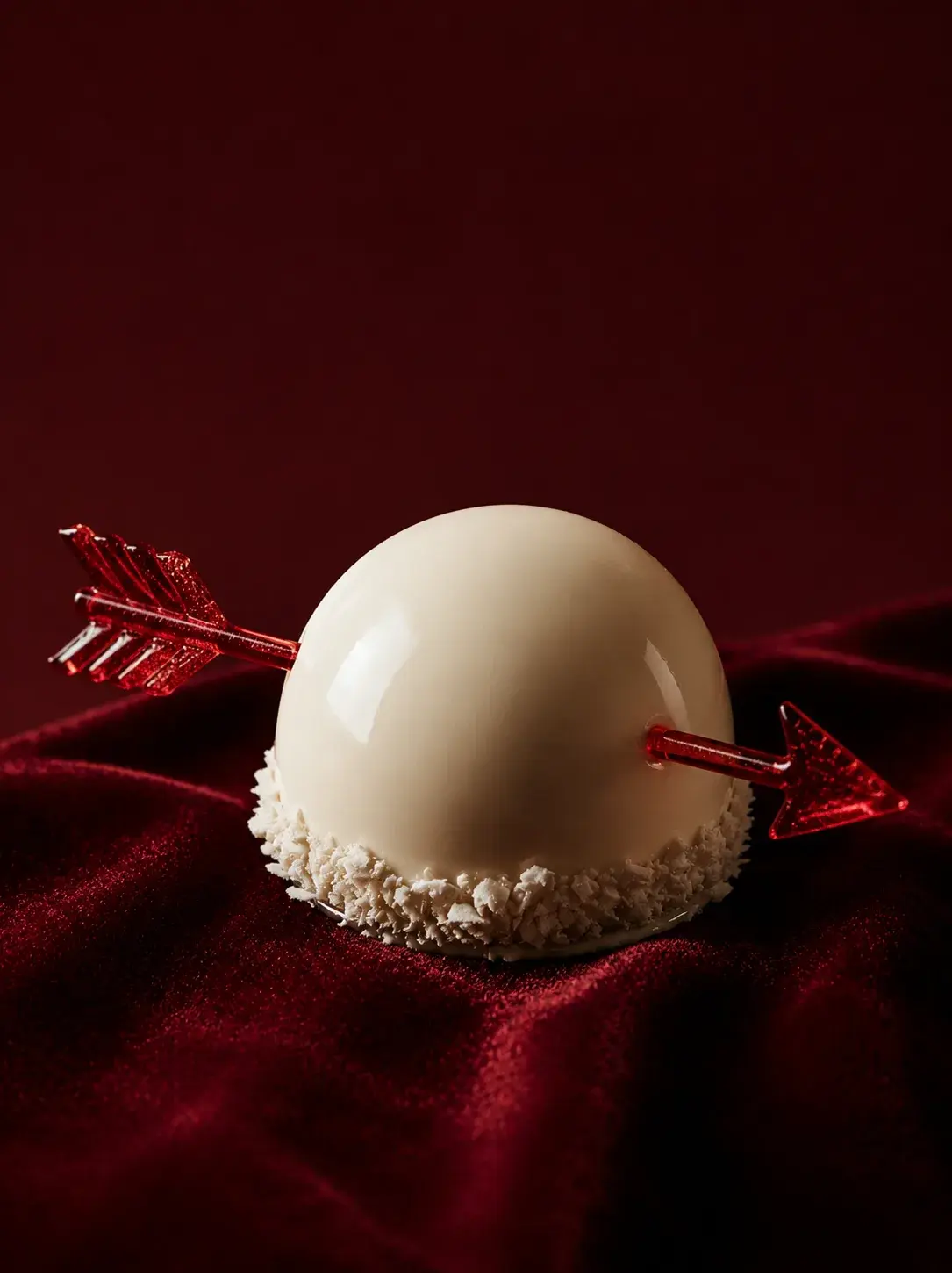 Entremets sphérique blanc avec flèche Cupidon en sucre rouge – velours bordeaux, saint-valentin