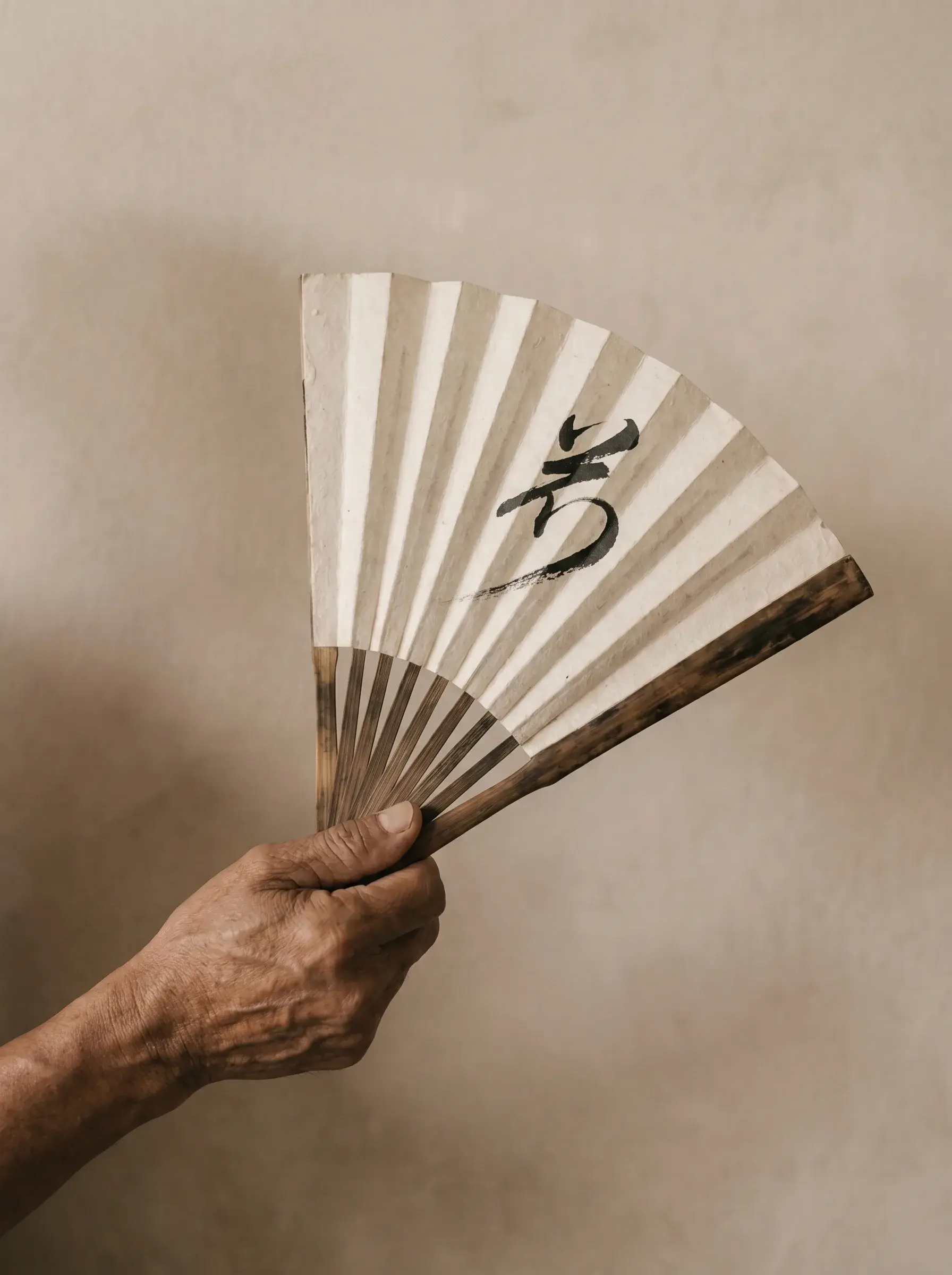 Éventail en papier blanc déployé – artisanat japonais, minimalisme, fond clair, lumière rasante