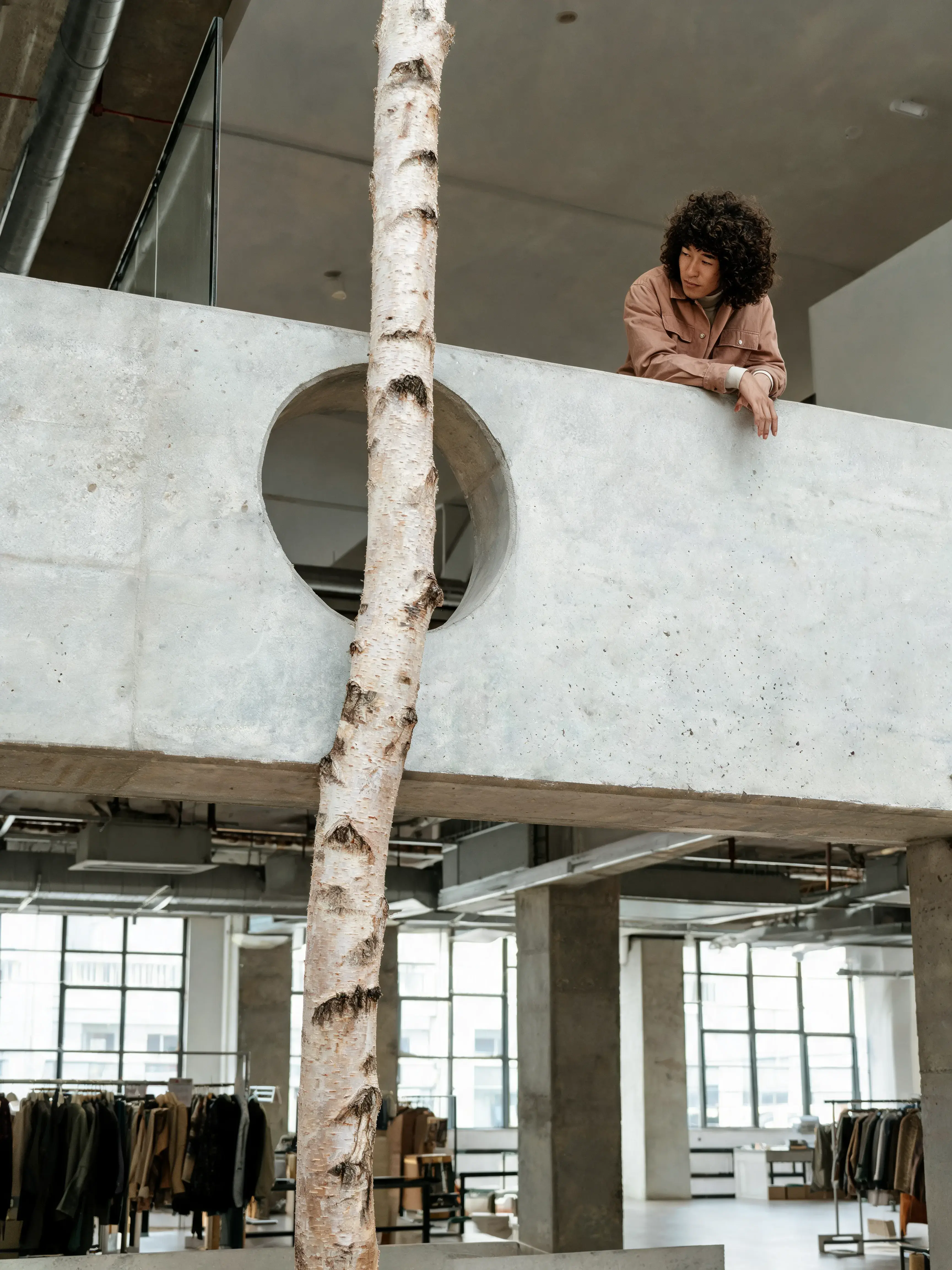 Femme bouclée se penchant sur mezzanine tronc bouleau