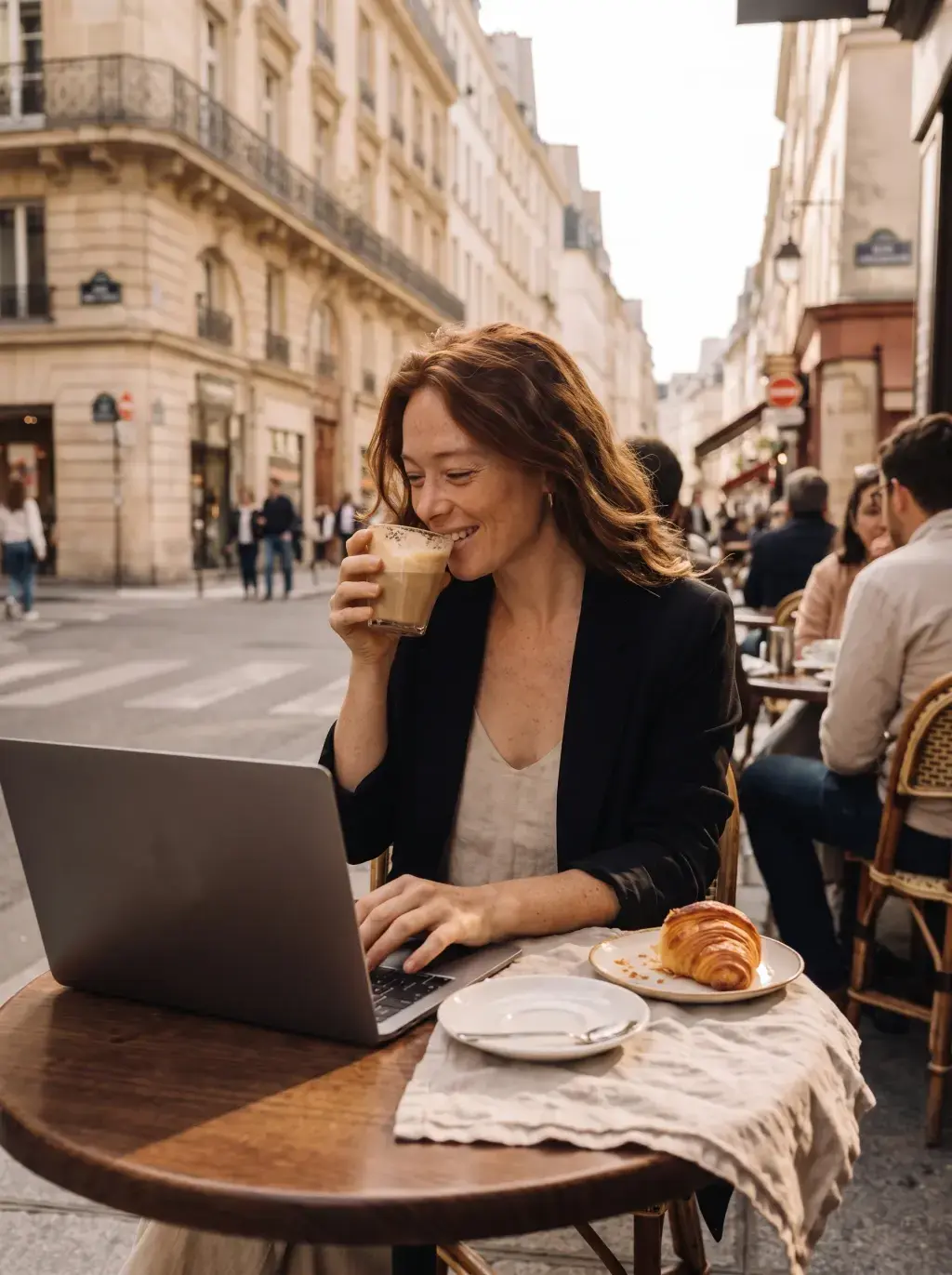 Femme buvant un café latte en travaillant en terrasse à Paris