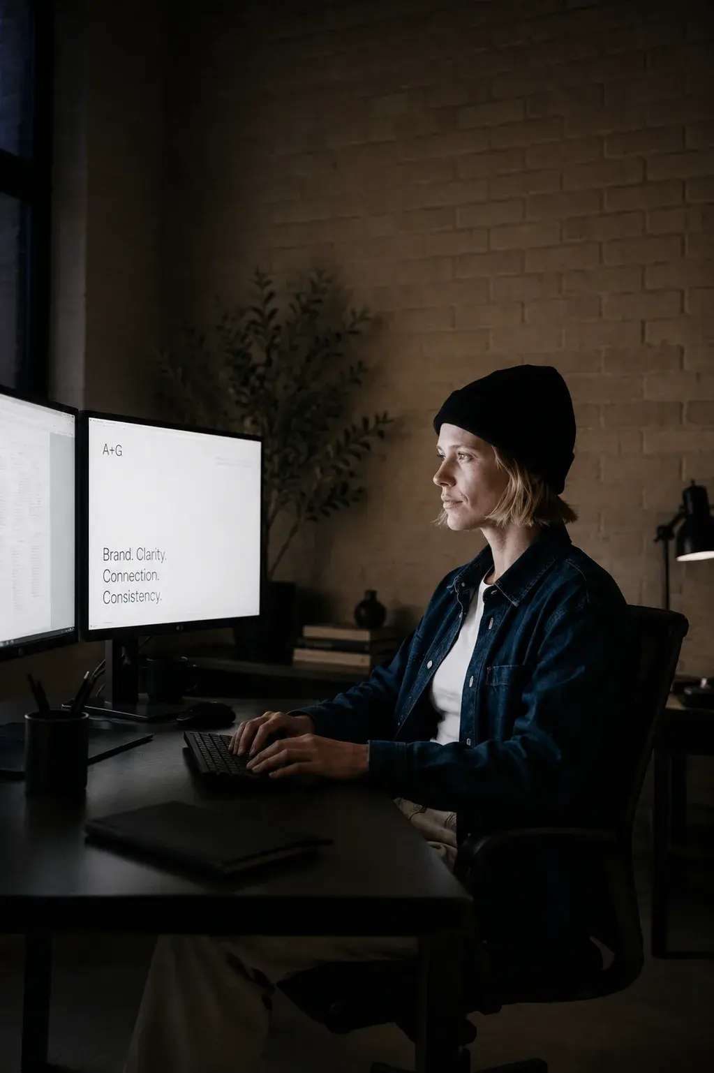 Femme de profil dans l'obscurité devant double écran affichant les objectifs de marque « Brand Goals: Coherence, Consistency »