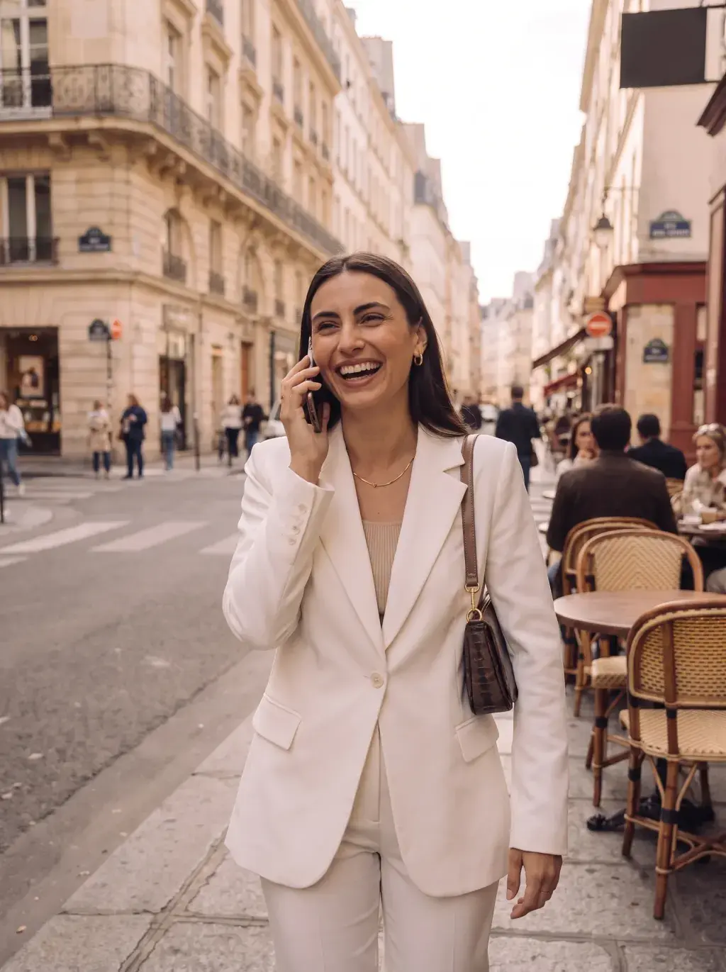 Femme en tailleur blanc téléphonant dans une rue parisienne