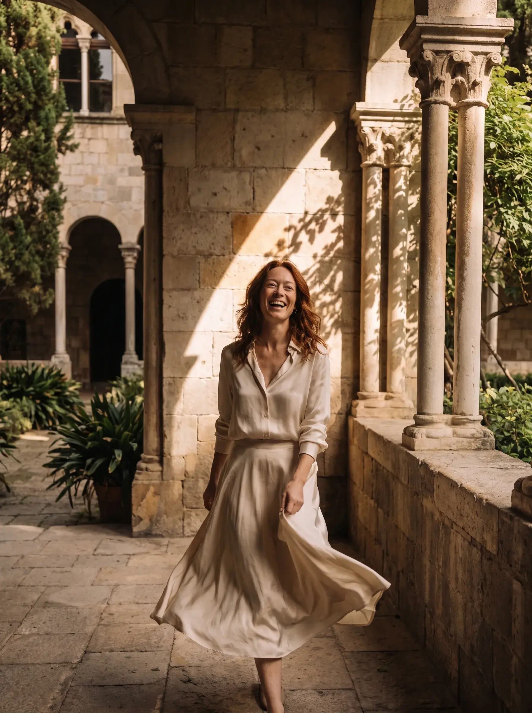 Femme marchant dans un cloître provençal en robe beige au soleil