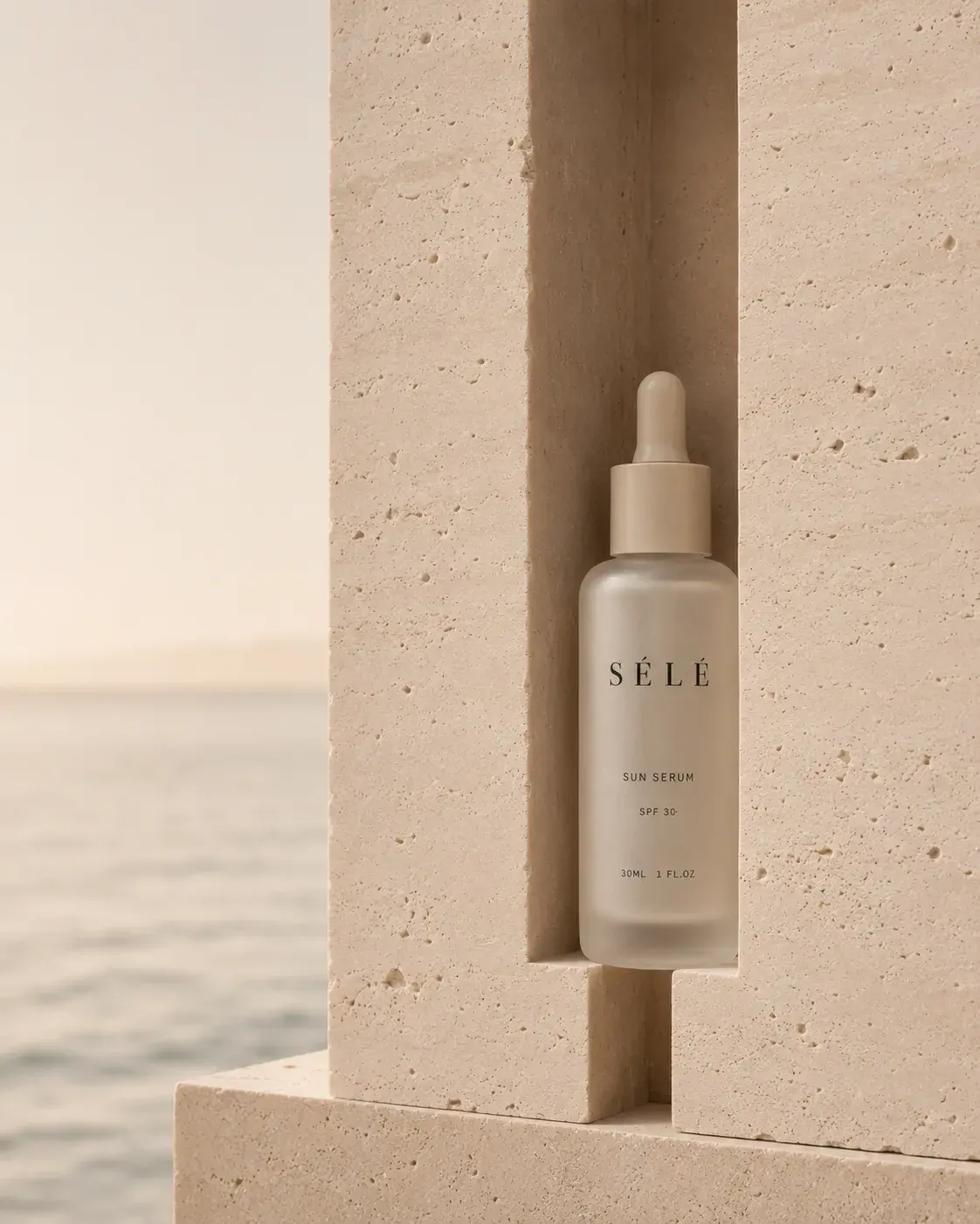 Flacon sérum pipette dans niche de pierre – coucher de soleil sur mer en fond, lumière dorée