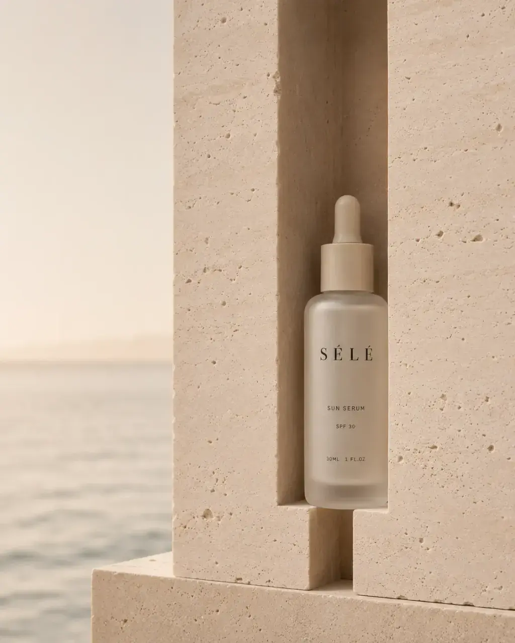 Flacon sérum pipette dans niche de pierre – coucher de soleil sur mer en fond, lumière dorée