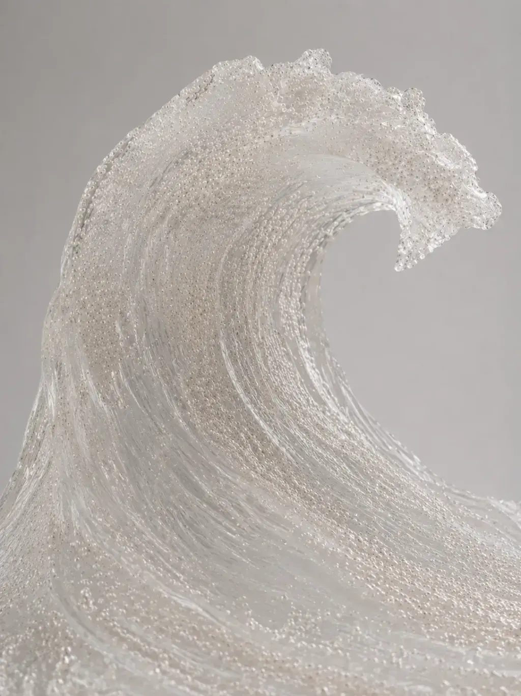 Grande vague sculptée en micro-perles et cristaux translucides, détail de la crête déferlante, fond gris
