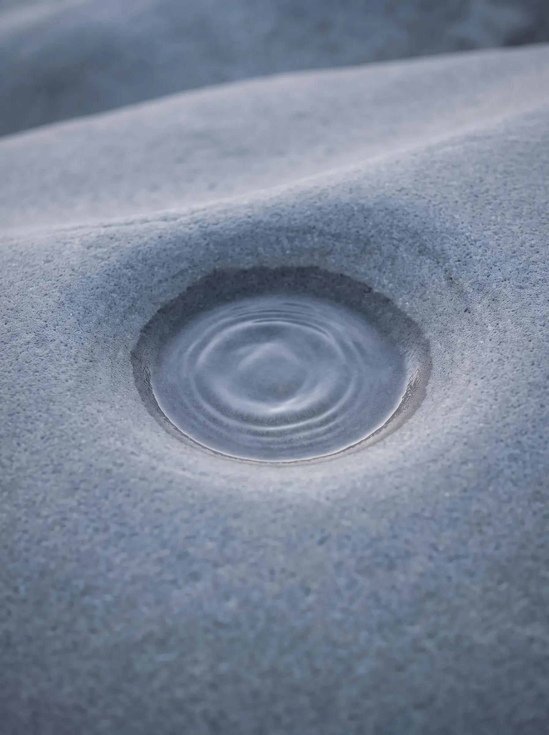 Gros plan d'une flaque d'eau dans le sable avec des cercles concentriques