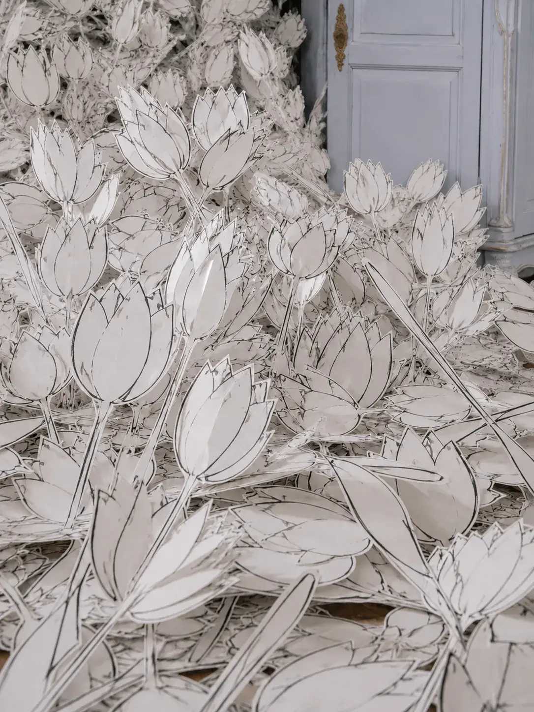 Gros plan installation de tulipes en papier découpé avec traits d'encre – sol haussmannien