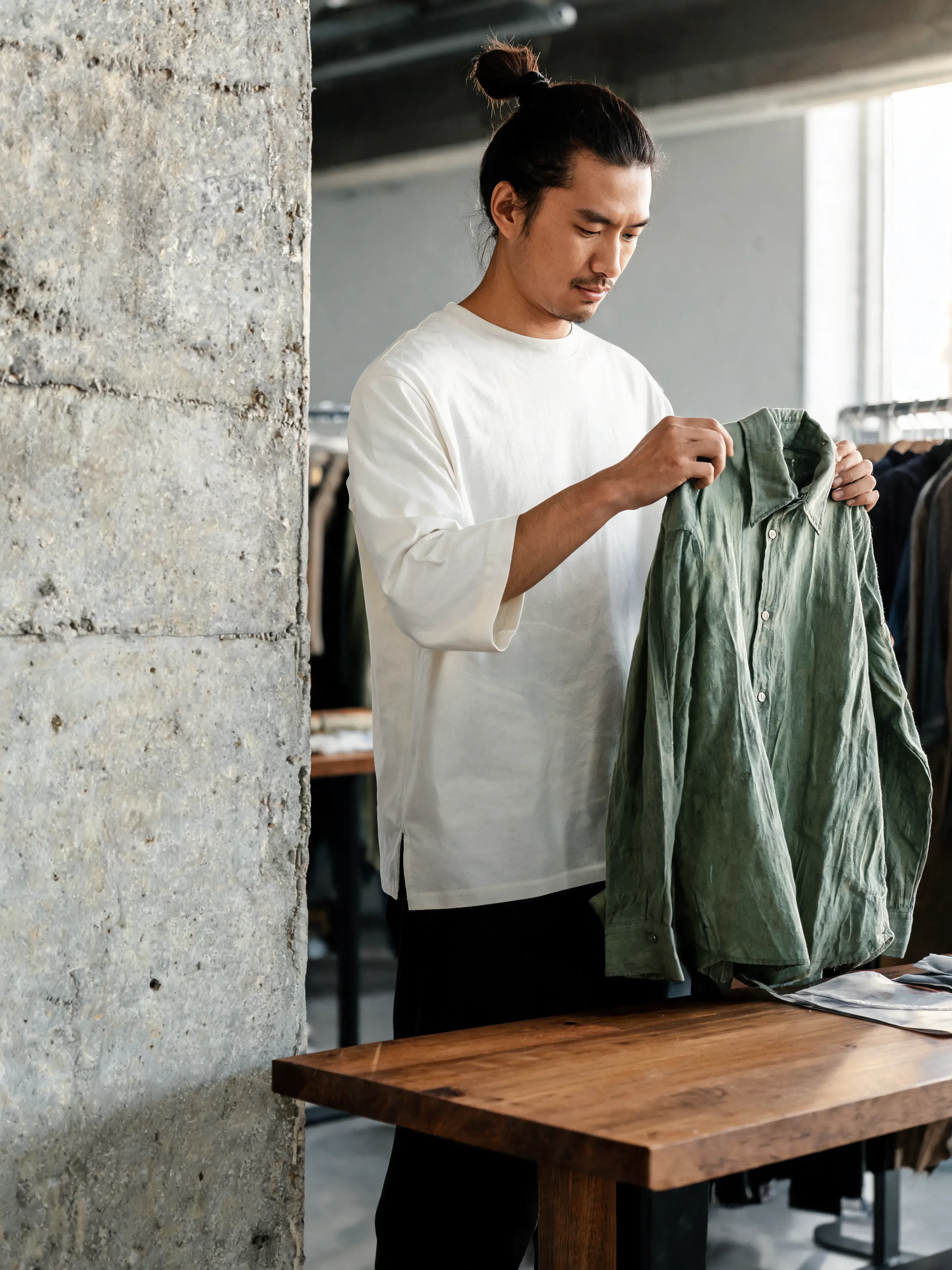 Homme examinant veste verte en boutique