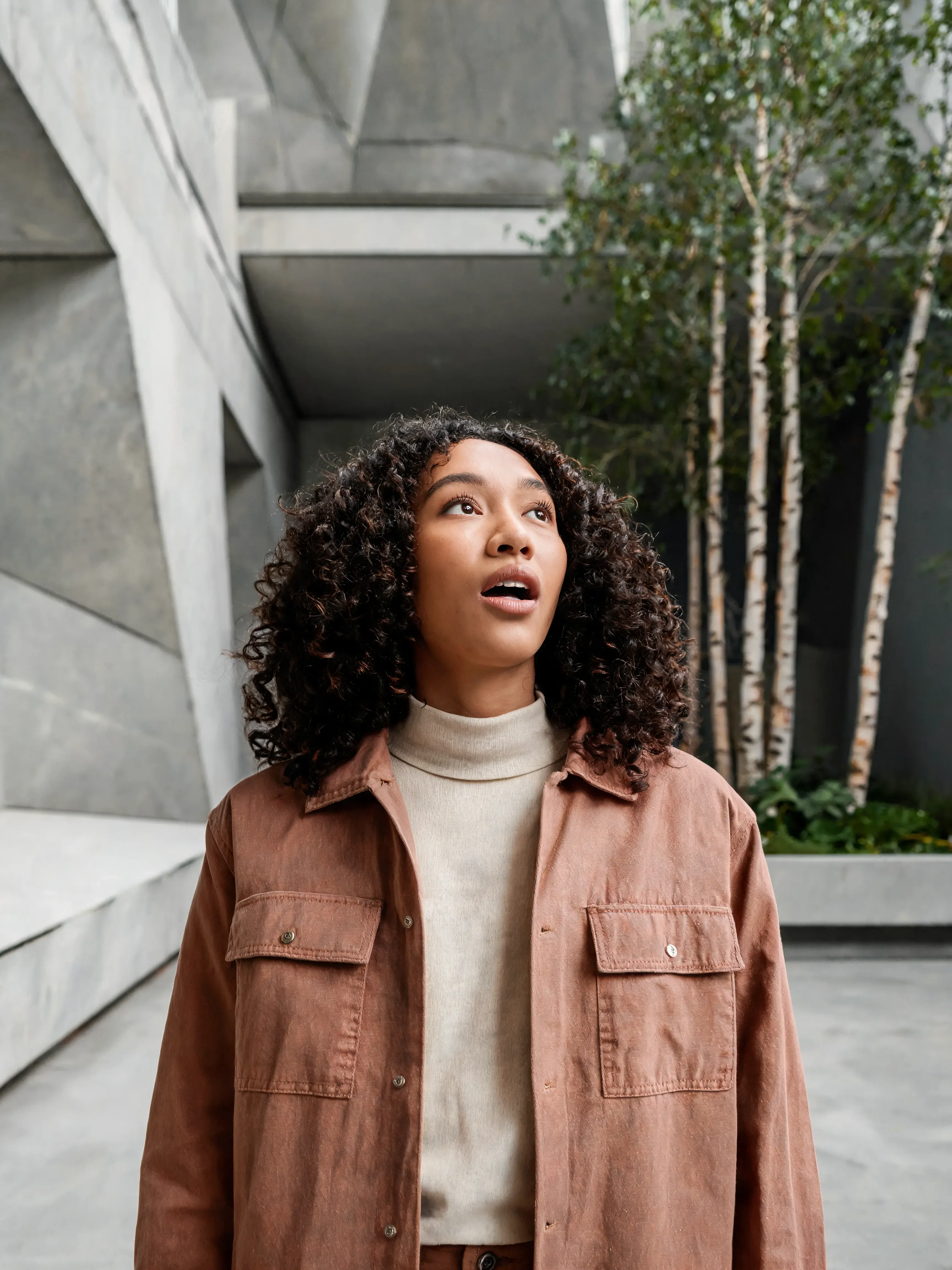 Jeune femme bouclée veste terracotta en ville