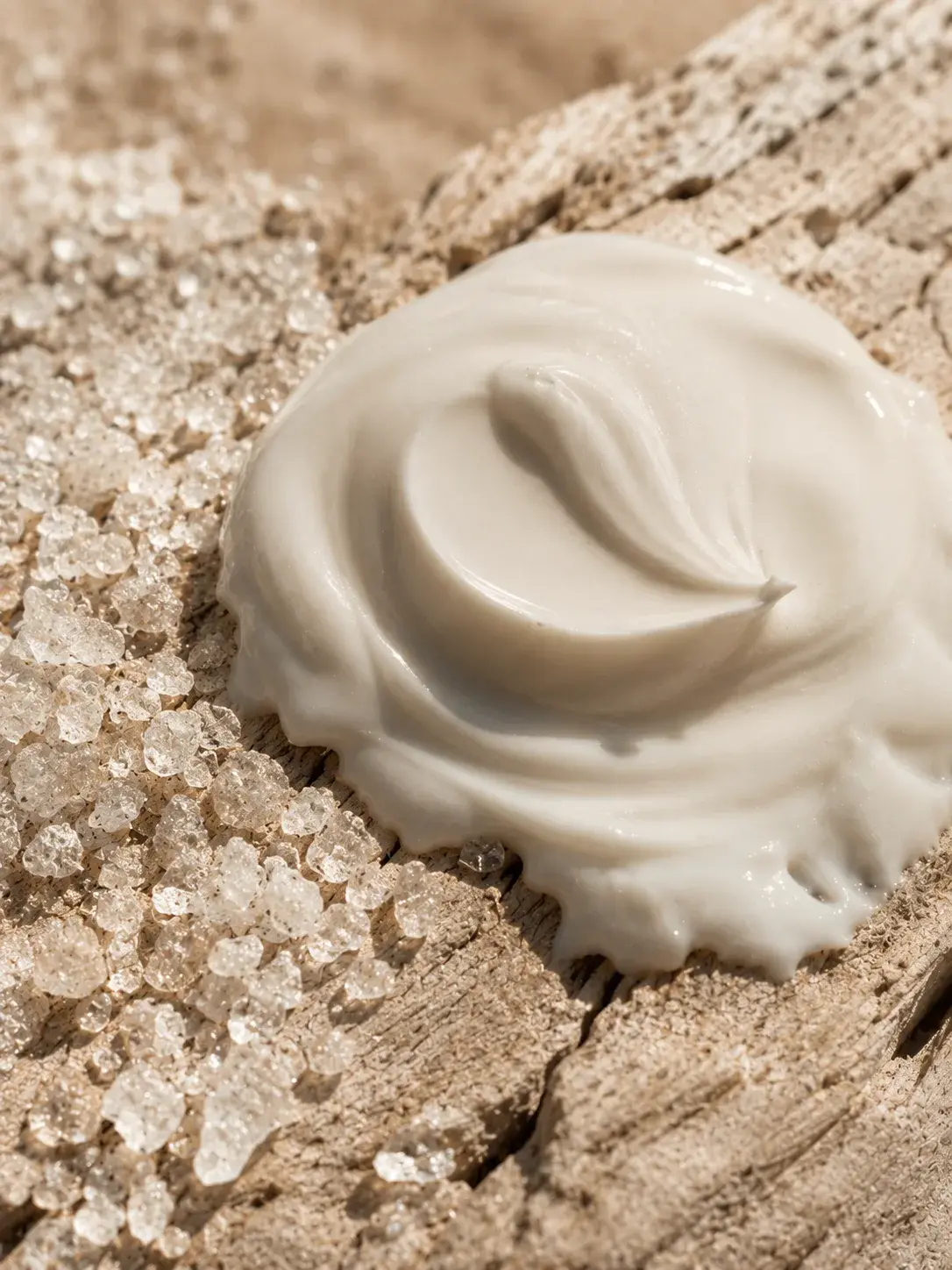 Macro dôme de crème blanche sur bois flotté craquelé – cristaux de sel, texture cosmétique