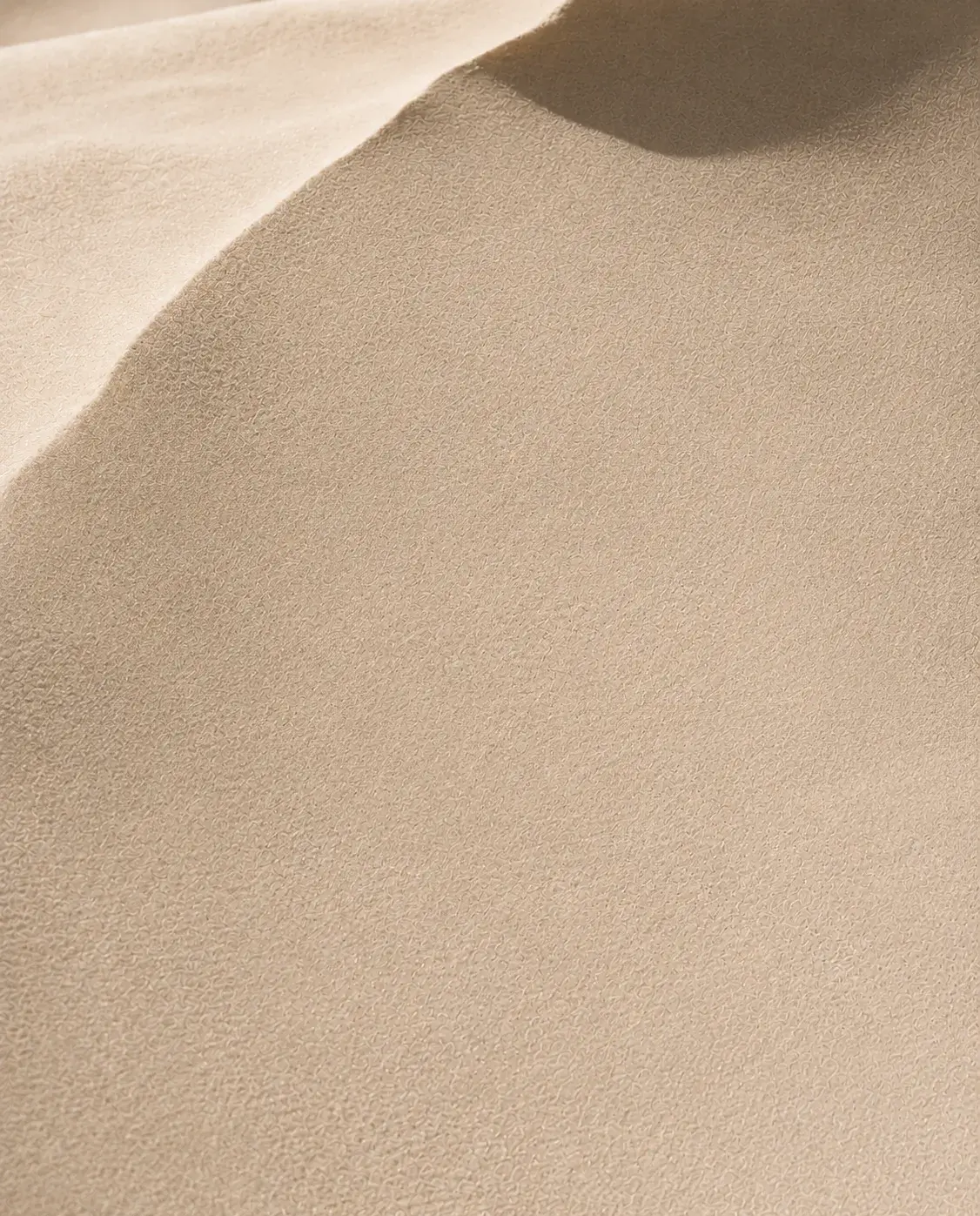 Macro texture de dune de sable fin – ondulations, courbes douces, lumière rasante, ombre