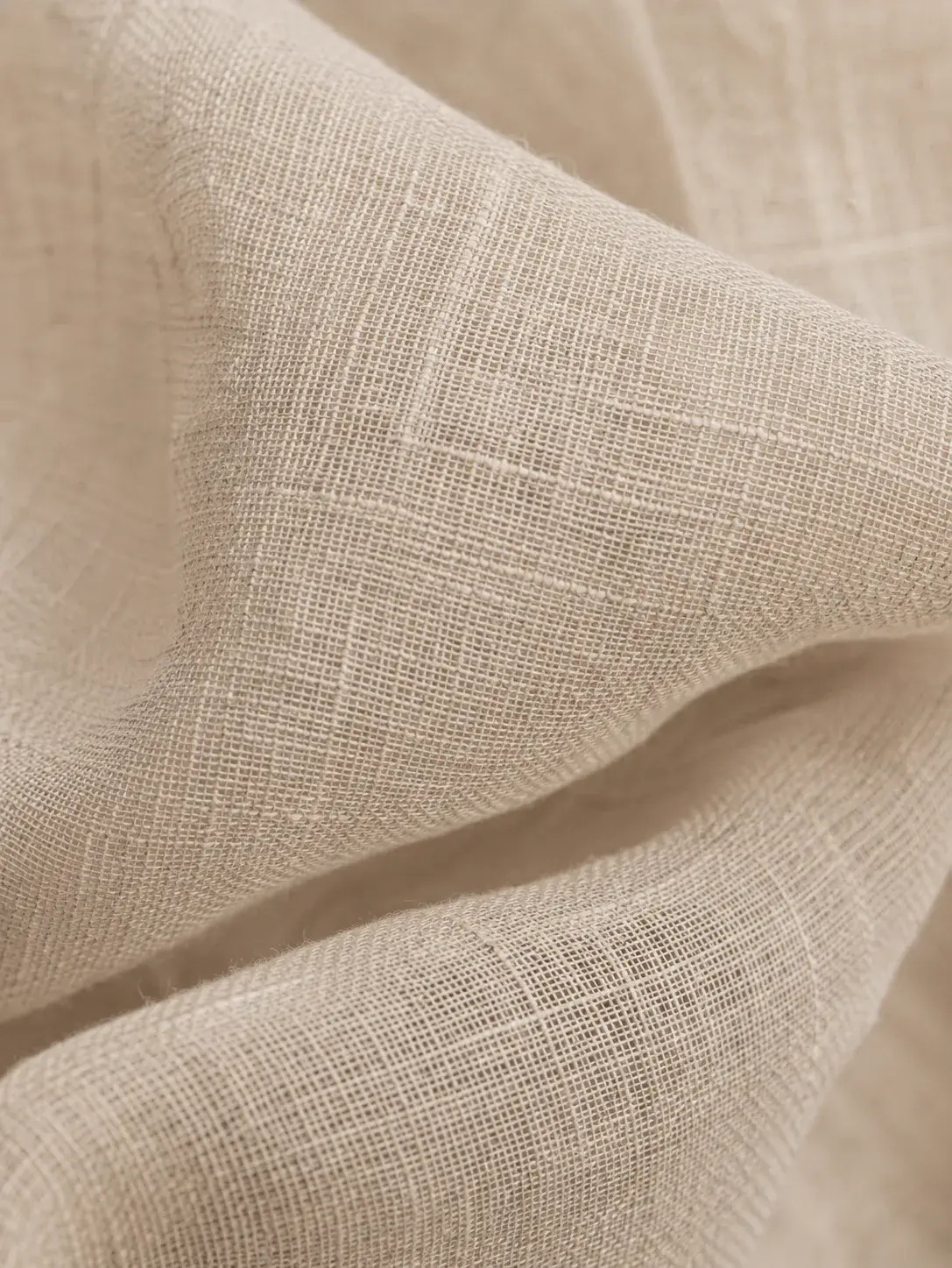 Macro tissu lin beige naturel froissé – texture fibre végétale, plis doux, fond neutre