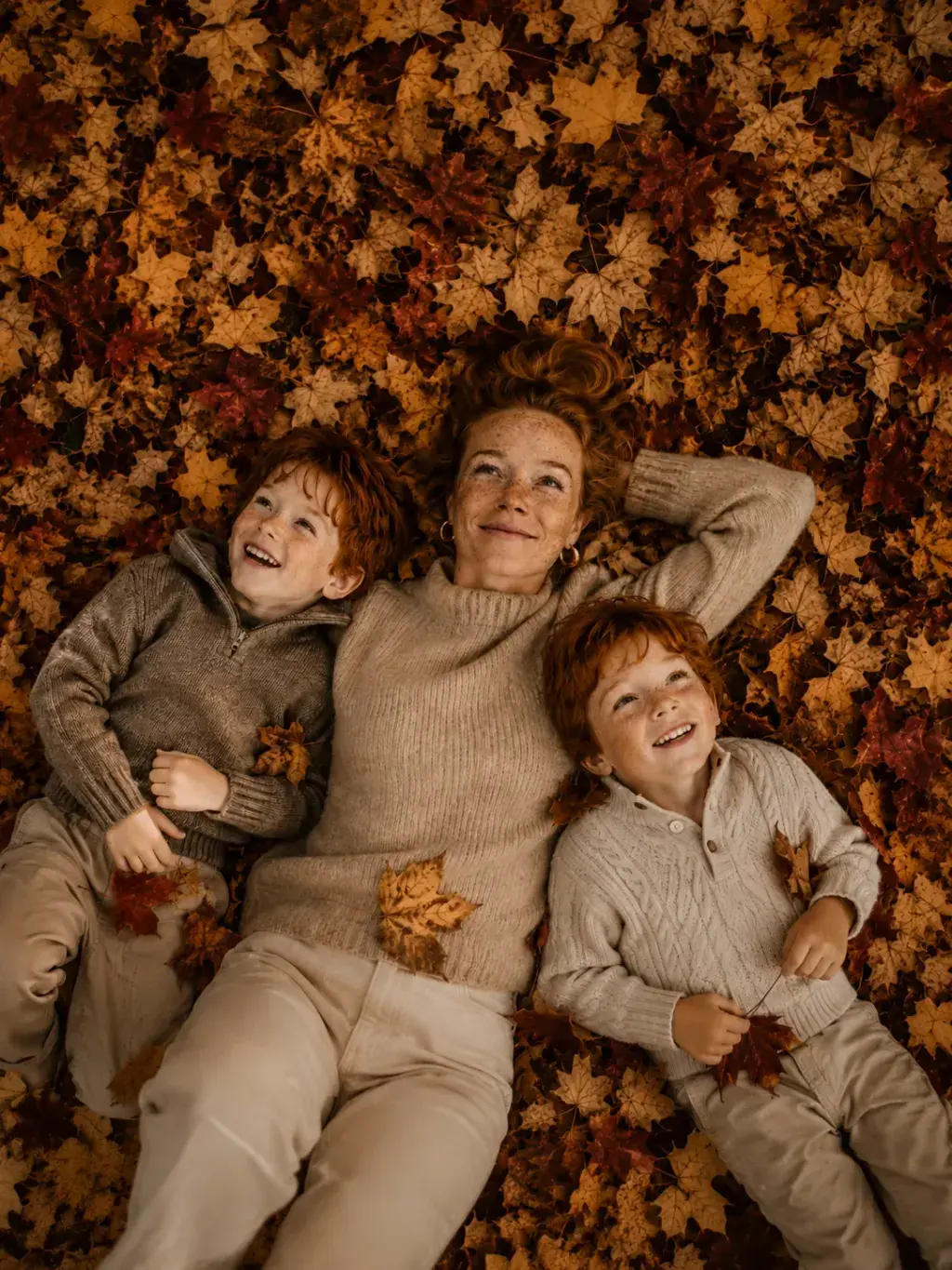 Mère et fils allongés dans les feuilles d'automne
