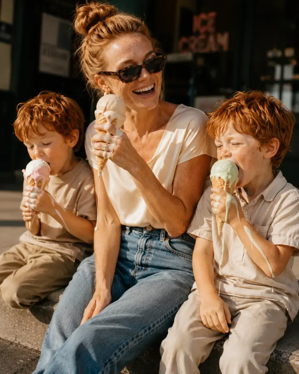 Mère et fils dégustant des glaces assis sur les marches d'une boutique