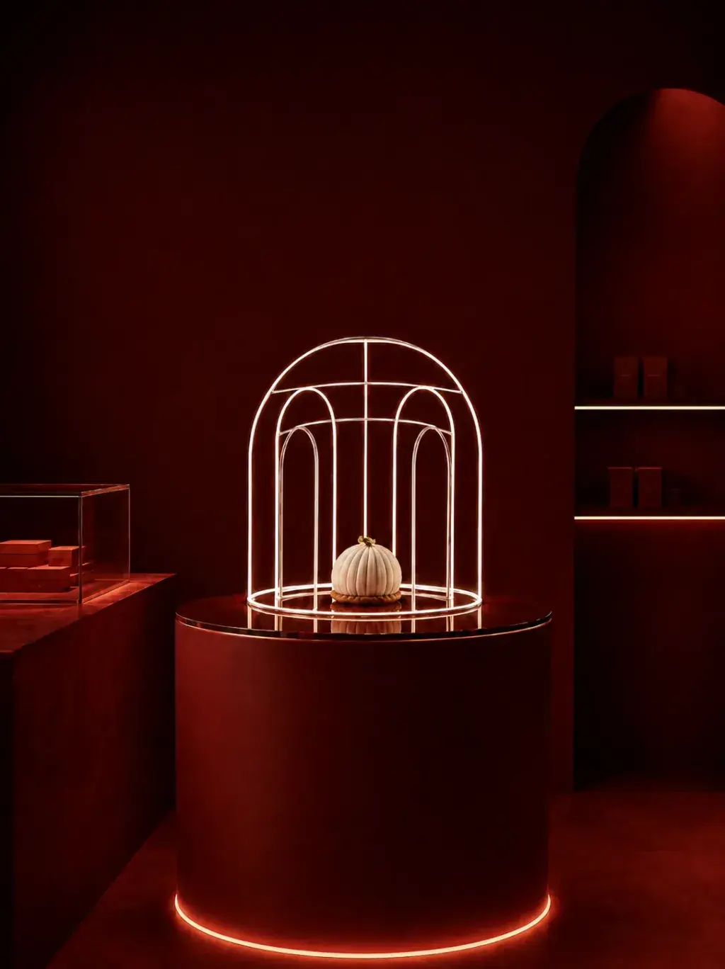 Pâtisserie en forme de citrouille côtelée blanche sous cage architecturale lumineuse en fils dorés, showroom rouge cramoisi