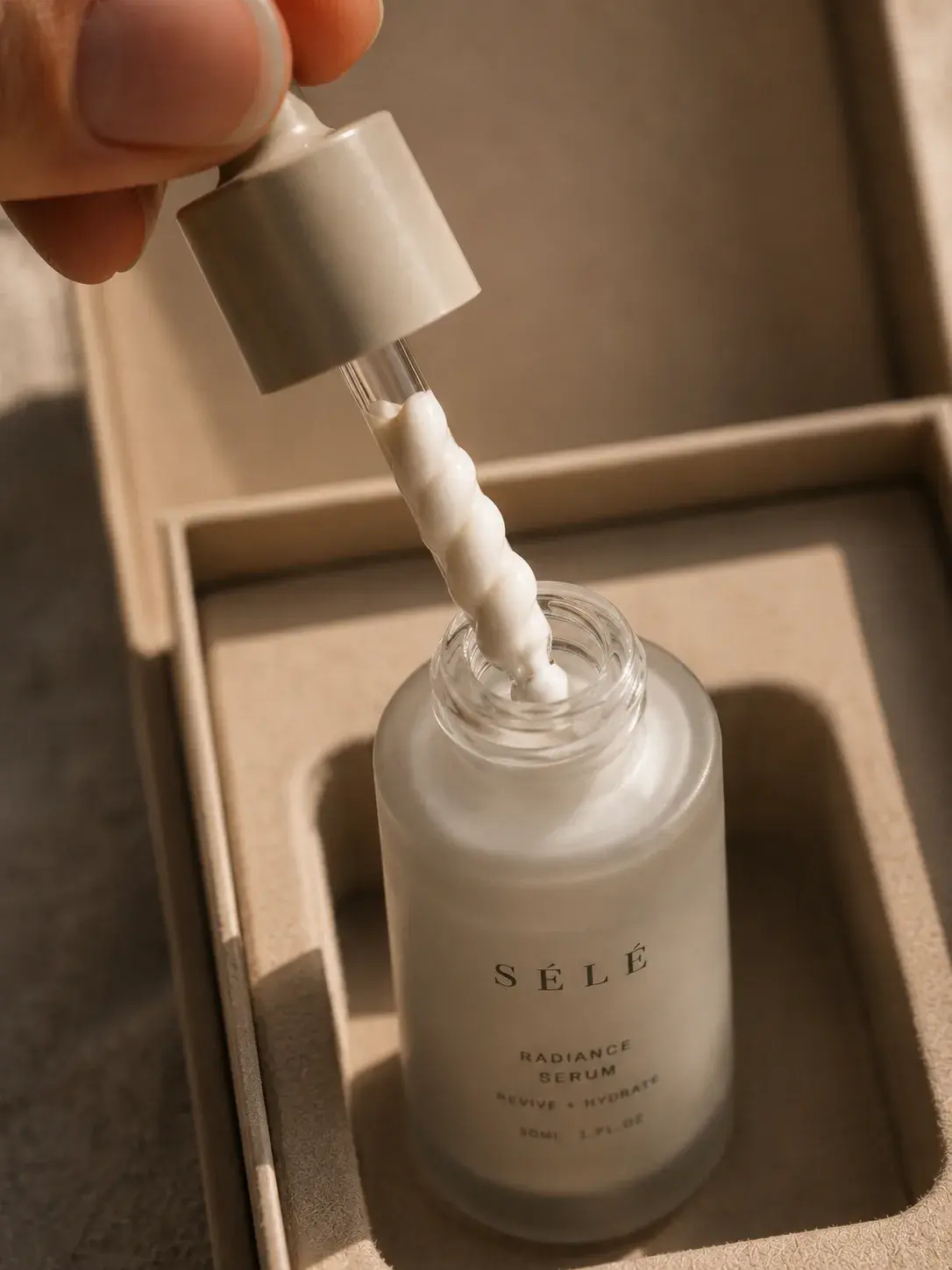 Pipette de sérum soulevée avec sérum perlé – flacon radiance dans coffret mousse, fond sombre