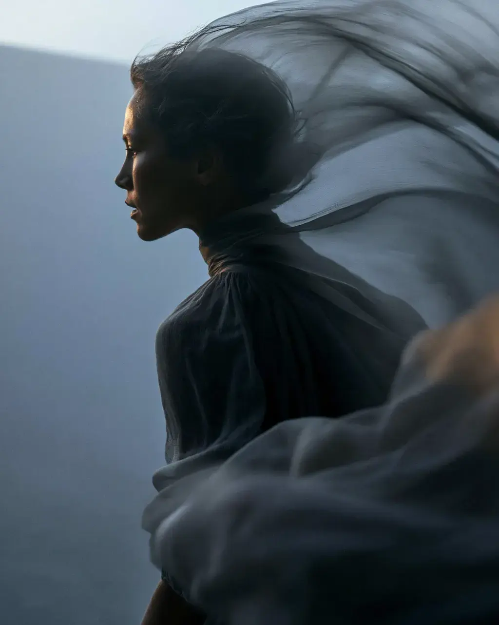 Portrait de profil femme – voile gaze translucide flottant autour de la tête, fond bleu-gris brumeux