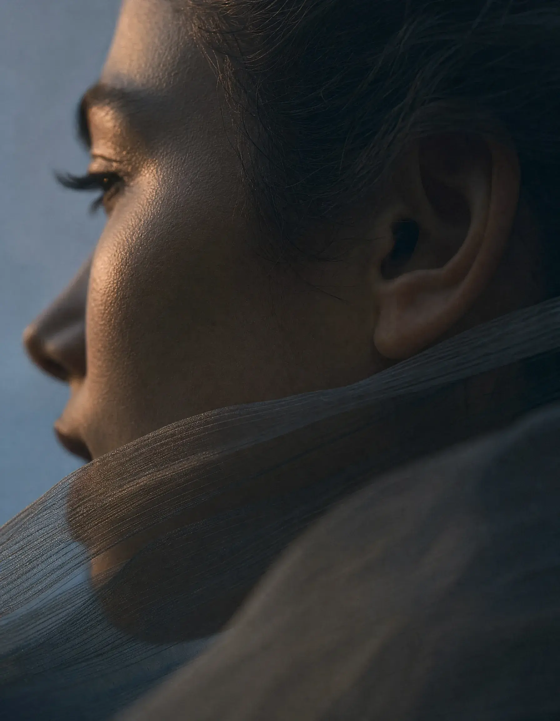 Portrait profil gros plan femme – voile gaze traversant le cou, lumière chaude dorée sur visage