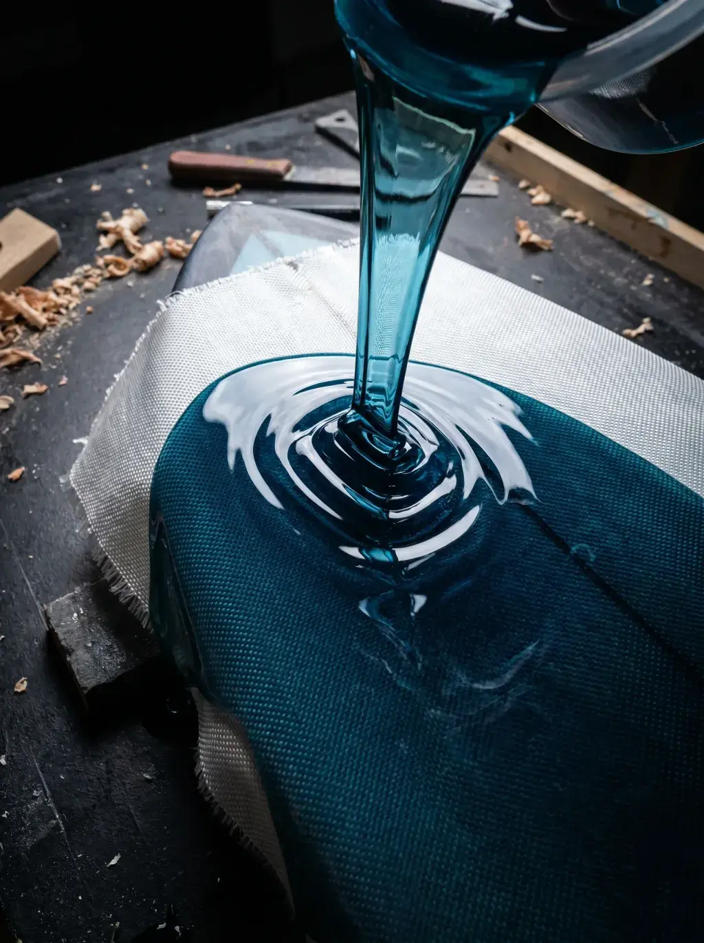 Résine bleue versée en spirale sur une planche de surf