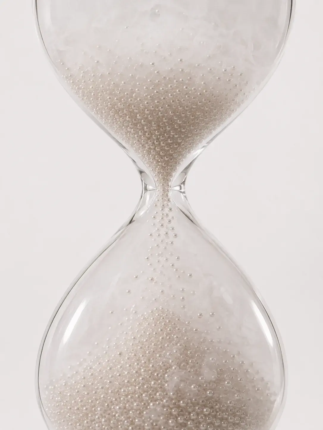 Sablier en verre rempli de micro-perles nacrées, symétrie du temps précieux