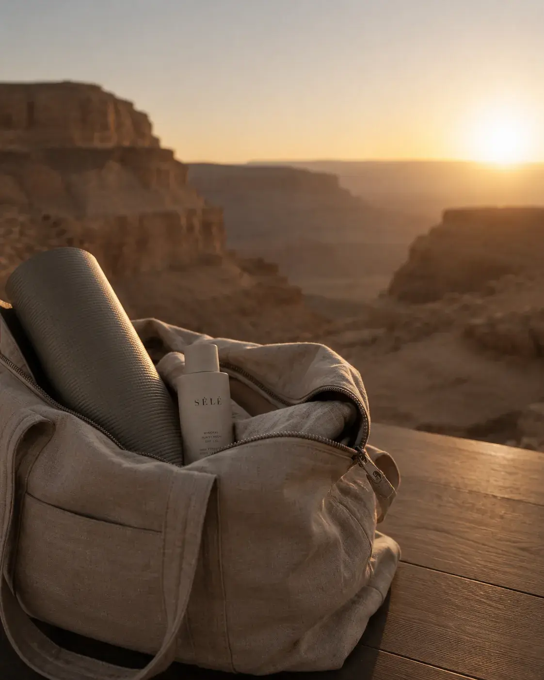 Sac canvas beige avec flacon soin sur balustrade – canyon désertique, coucher de soleil doré