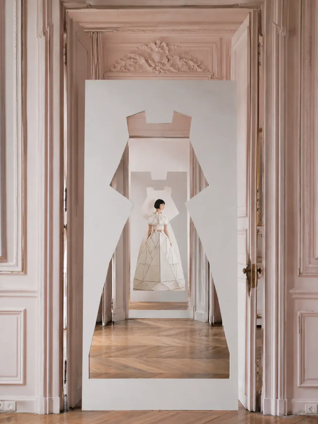 Silhouette de robe découpée dans une cloison – enfilade de salons haussmanniens roses