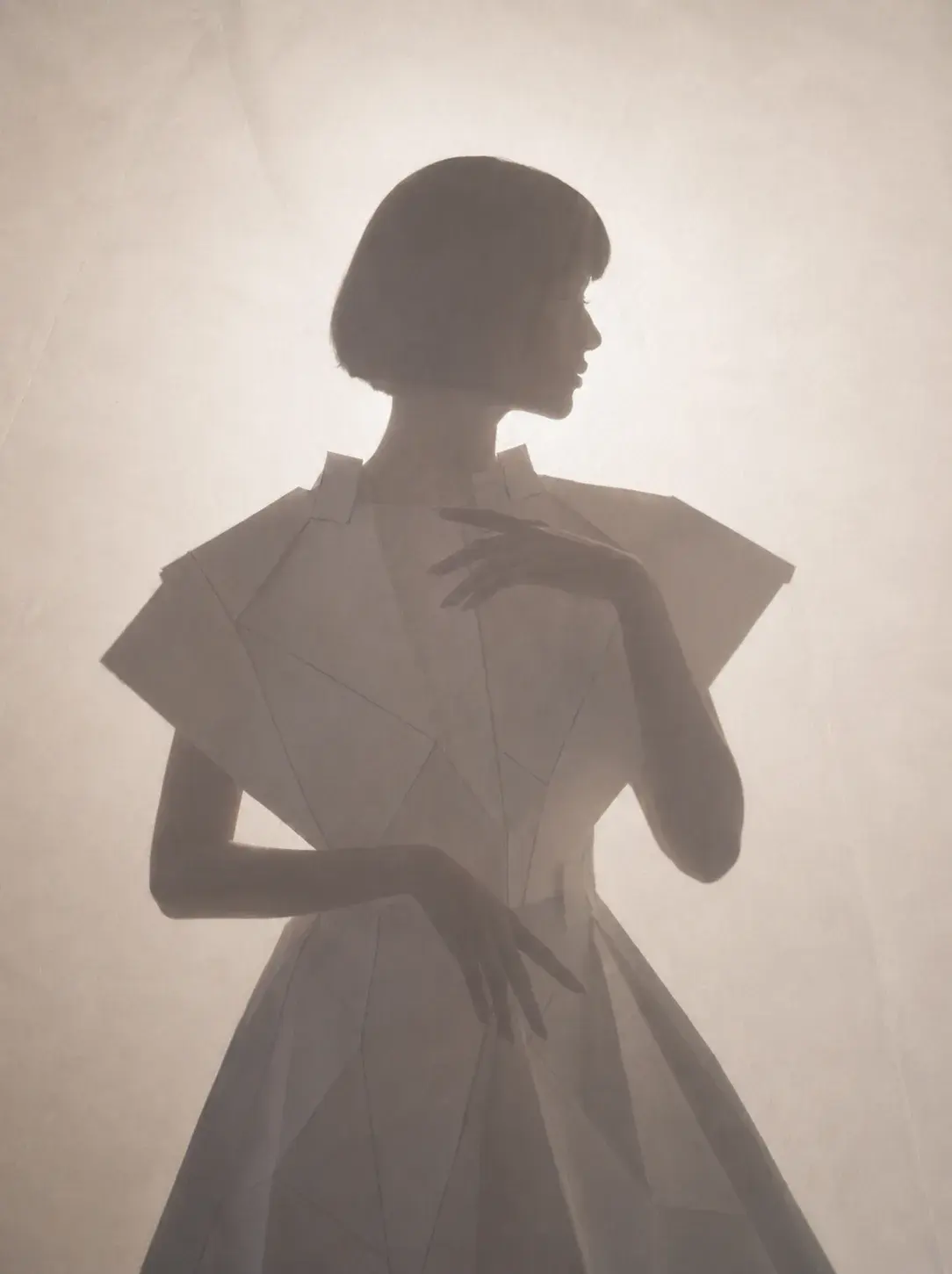 Silhouette féminine en robe blanche sculptée – atmosphère brumeuse et lumière diffuse